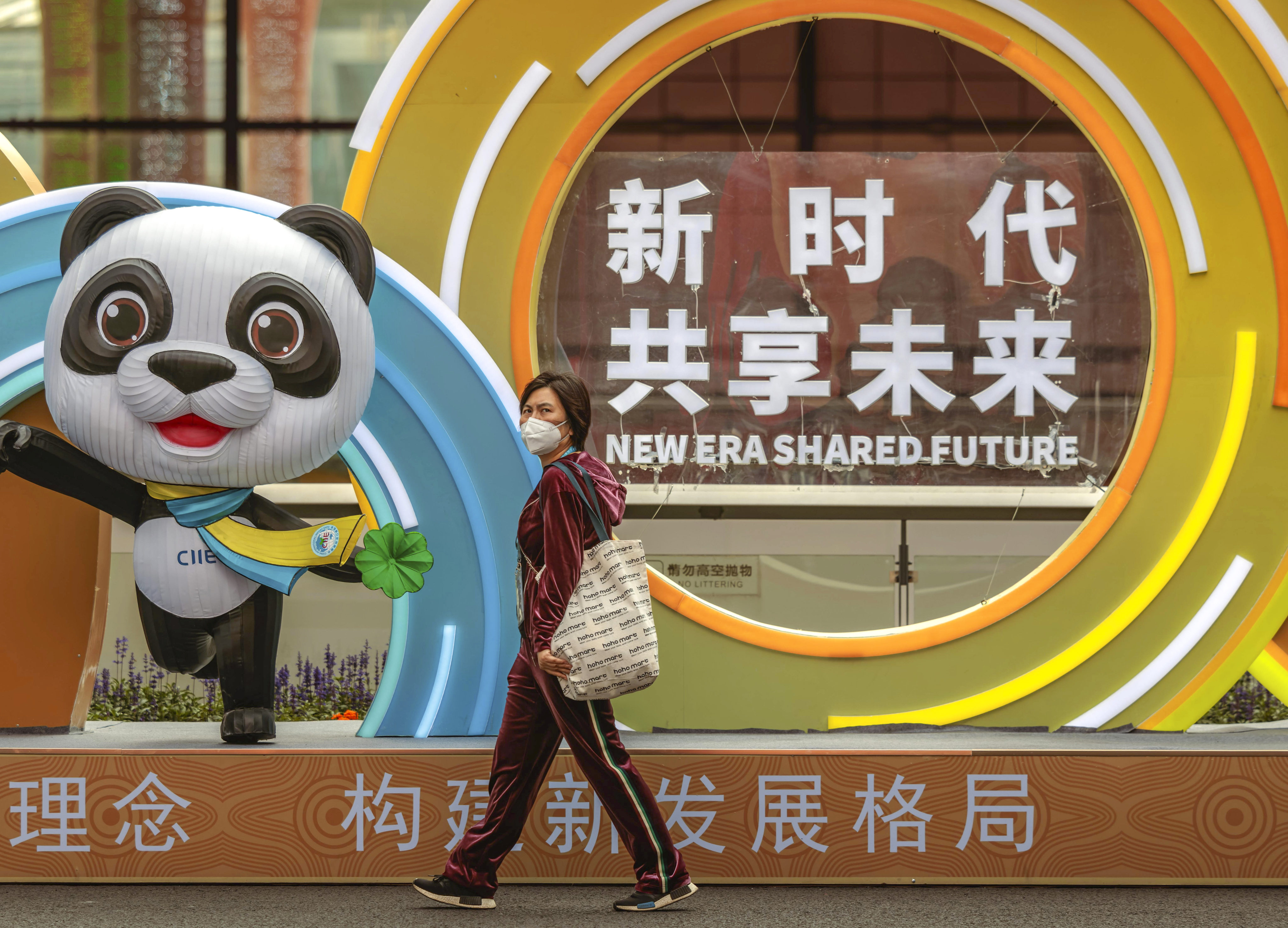 A woman walks past a mascot of the China International Import Expo in Shanghai, which continues until Thursday. Photo: EPA-EFE