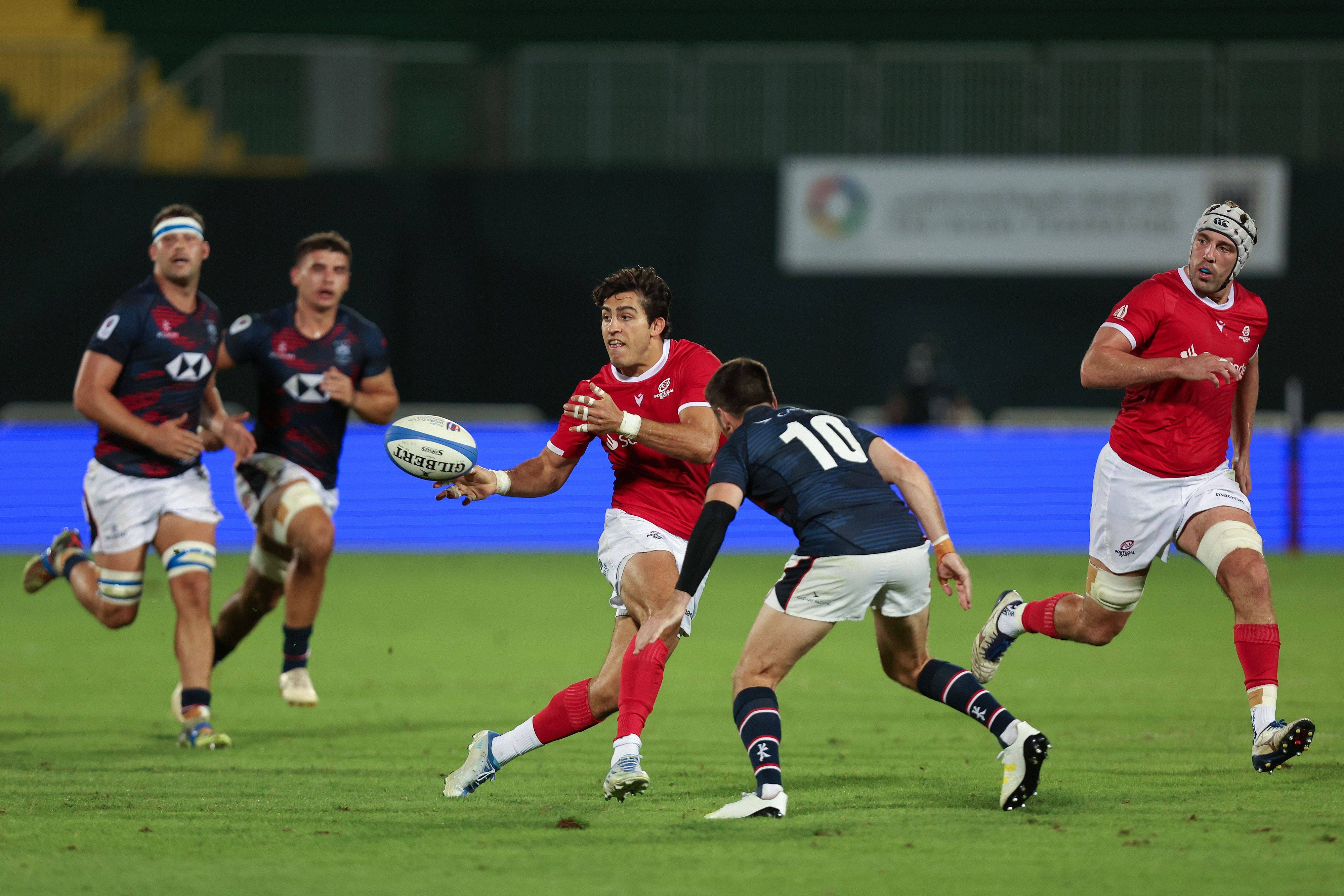 Tomas Appleton of Portugal offloads the ball while under pressure from Hong Kong’s Gregor McNeish at The Sevens Stadium in Dubai. Photo: World Rugby

