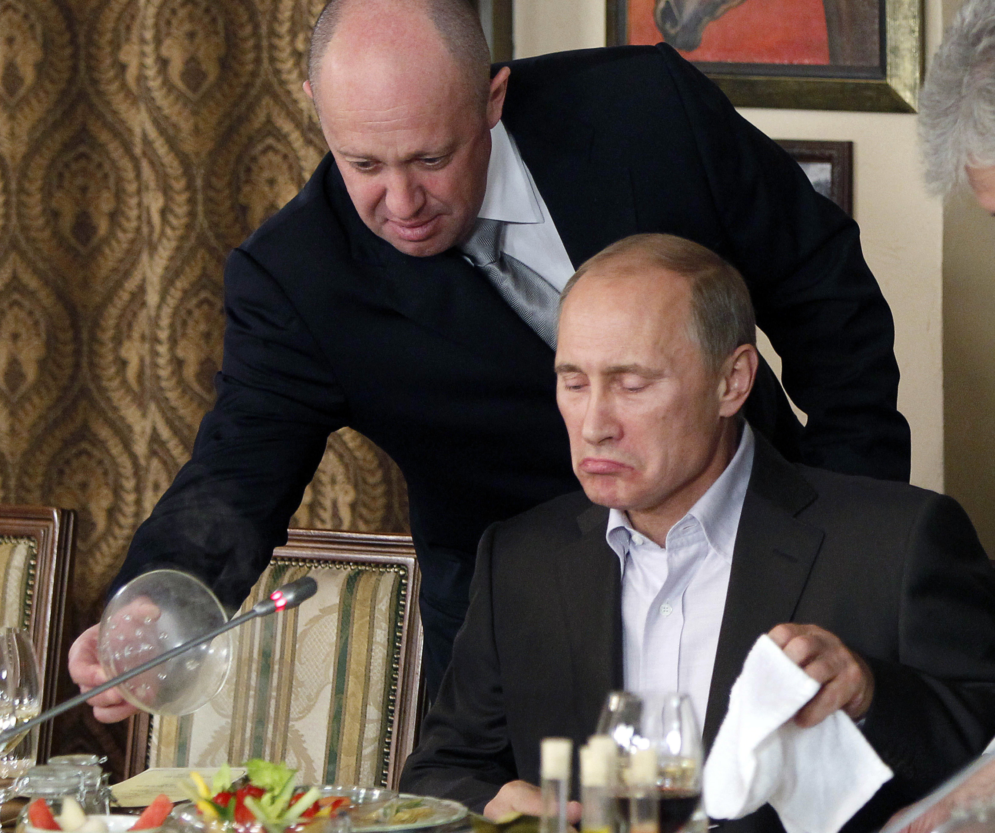 Yevgeny Prigozhin (left) serves food to Russian Prime Minister Vladimir Putin during dinner at Prigozhin’s restaurant outside Moscow in November 2011. Photo: AP