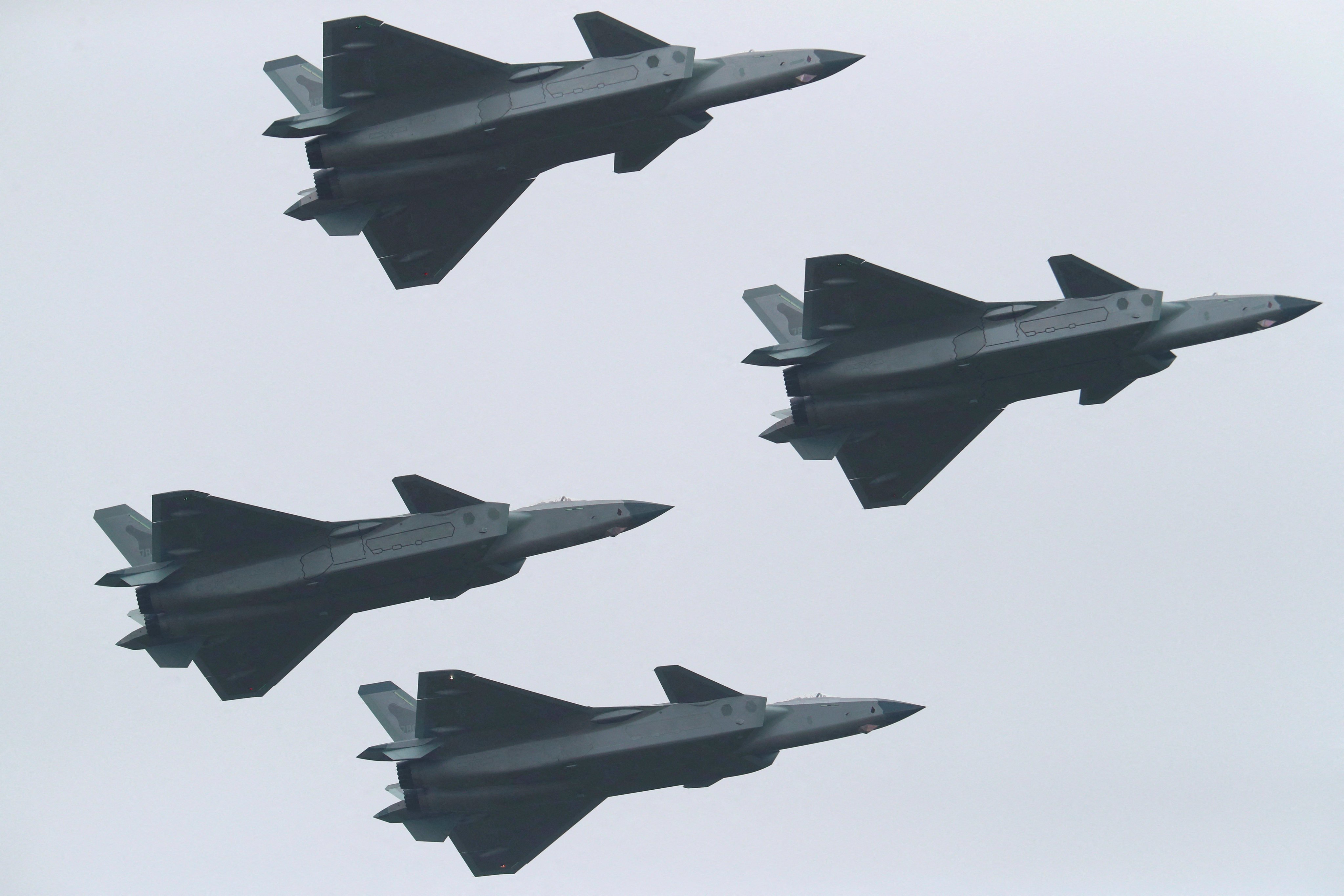 J-20 stealth fighter jets fly in formation at the Zhuhai air show in Guangdong on Tuesday. There will be more parking areas for fighter jets and other aircraft at an expanded base in the province. Photo: China Daily via Reuters