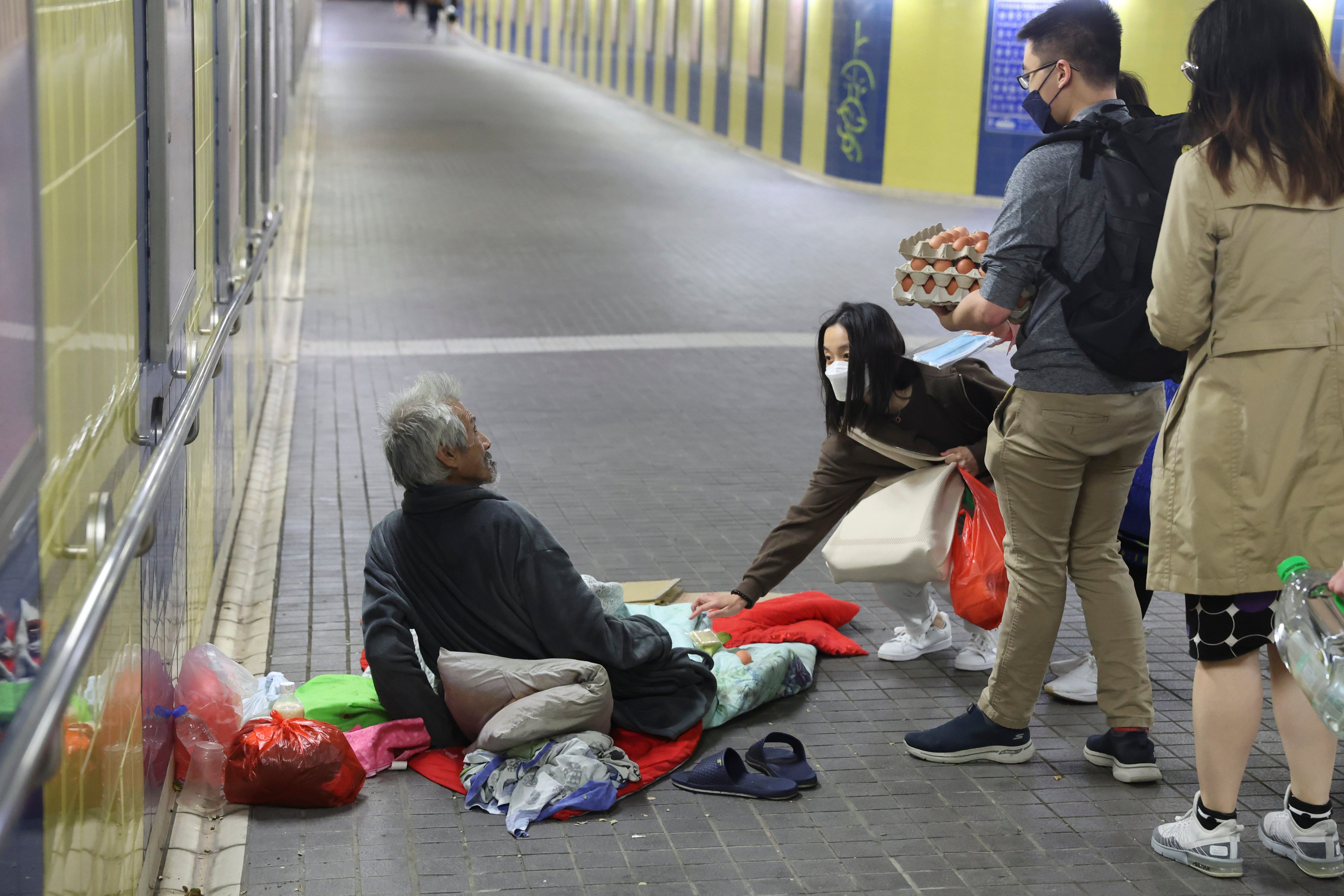 A street sleeper in Tsim Sha Tsui, Hong Kong, is provided with necessities during a “kindness walk” led by Alex Wong (second left) and organised through the homeless charity ImpactHK. Photo: Edmond So