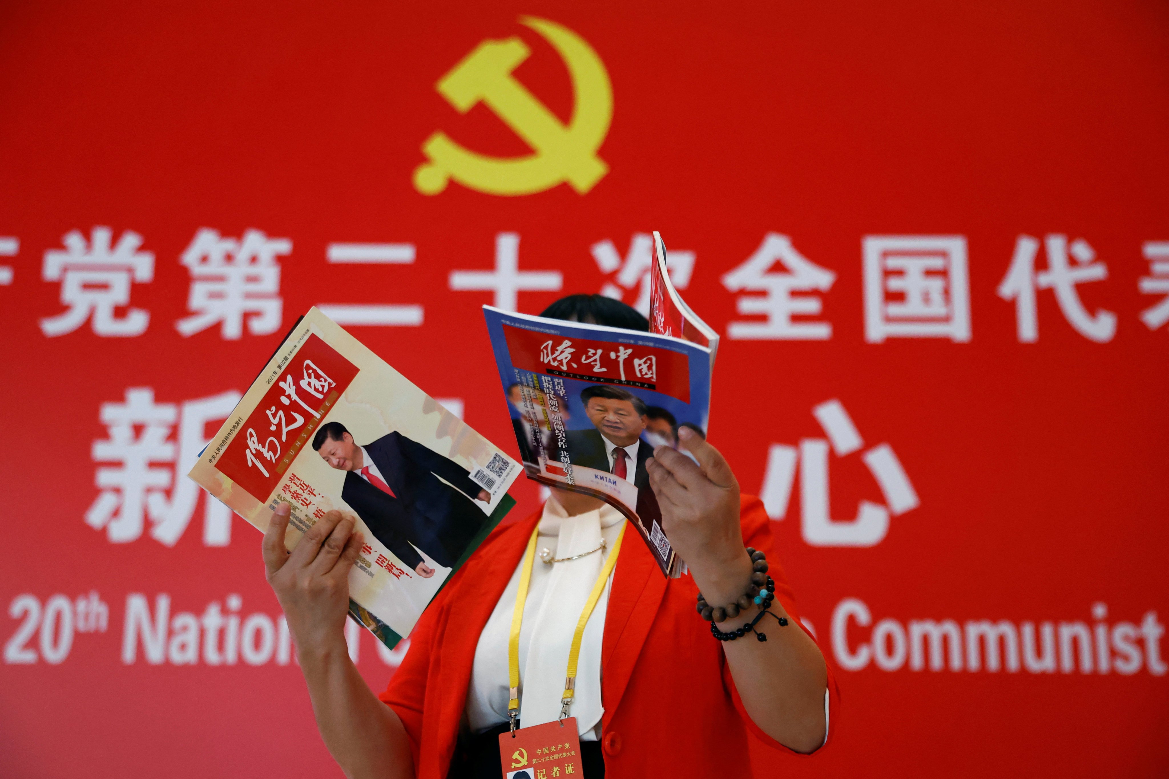 A journalist holds magazines featuring President Xi Jinping on the covers, at a hotel for journalists covering the 20th party congress in Beijing, on October 19. Photo: Reuters