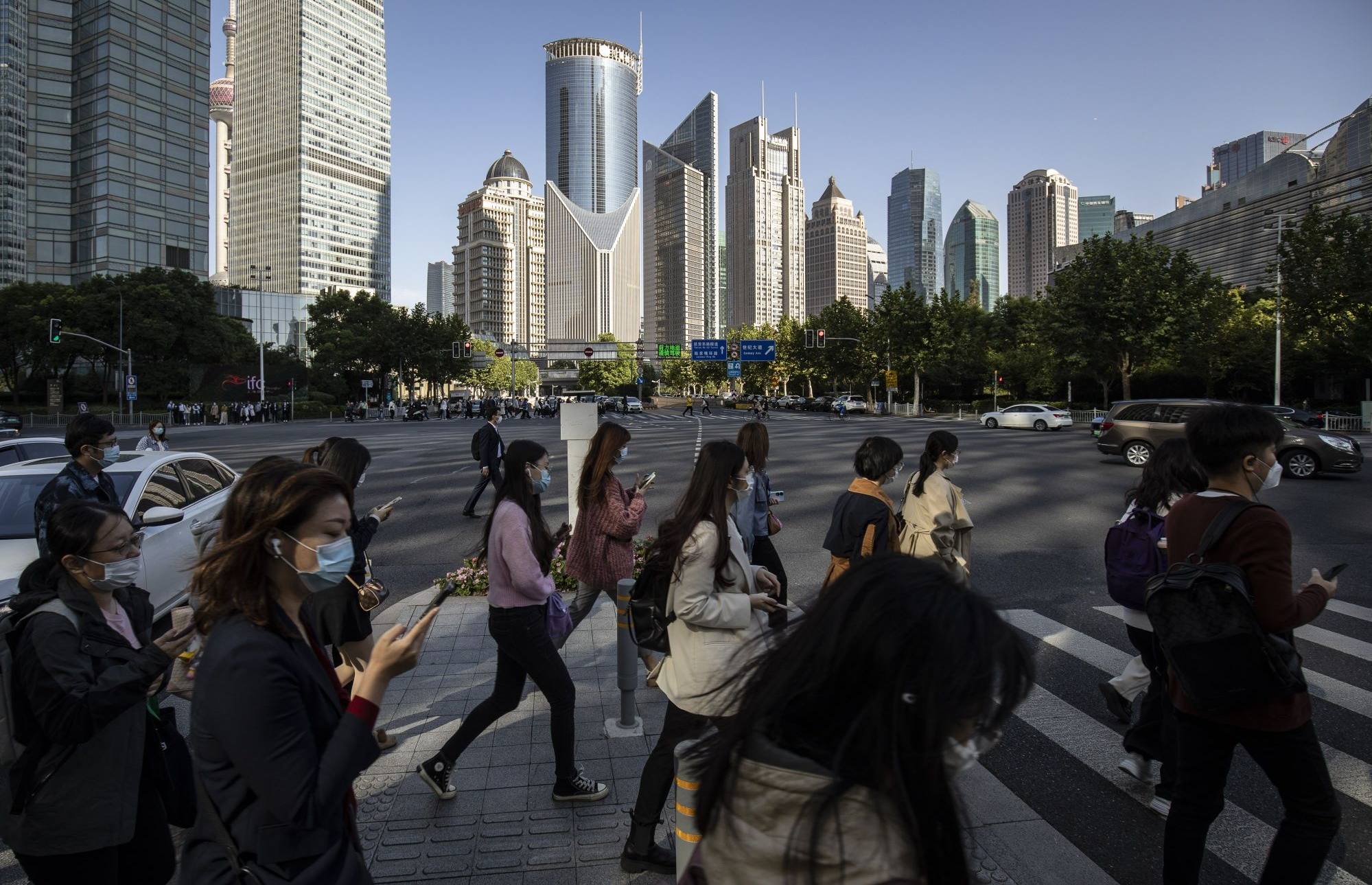 Pedestrians cross a road in the financial district of Shanghai on October 10. Photo: Bloomberg