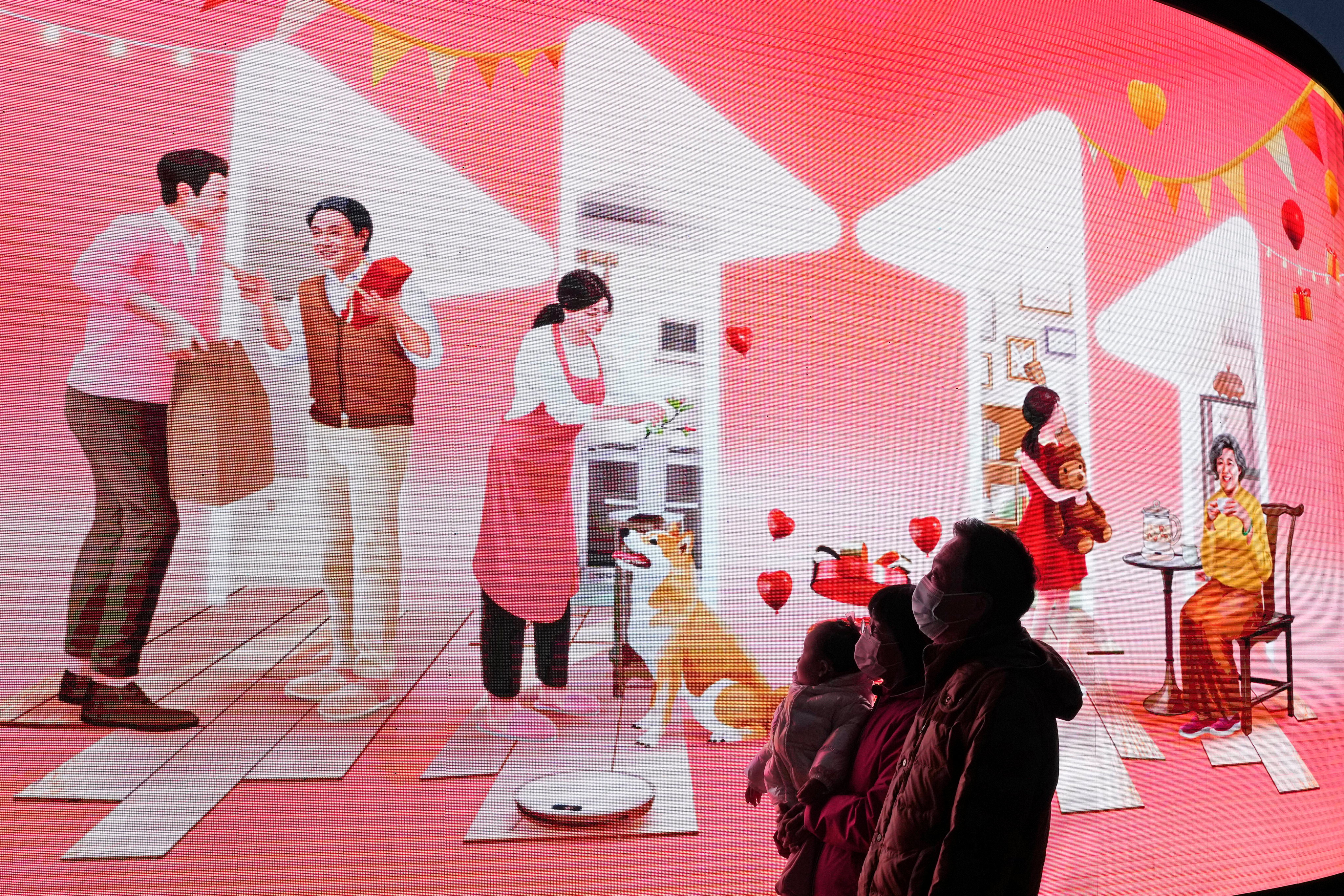 Shoppers outside a mall look up at an ad from JD.com for Singles’ Day in Beijing, China’s biggest online shopping festival. Photo: AP