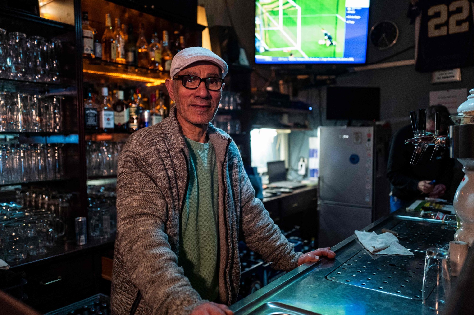 The owner of Salamas sports bar, Salama El Khatib, poses behind the counter of his establishment in Berlin. Salamas will be showing all the matches at the Qatar World Cup. Photo: AFP