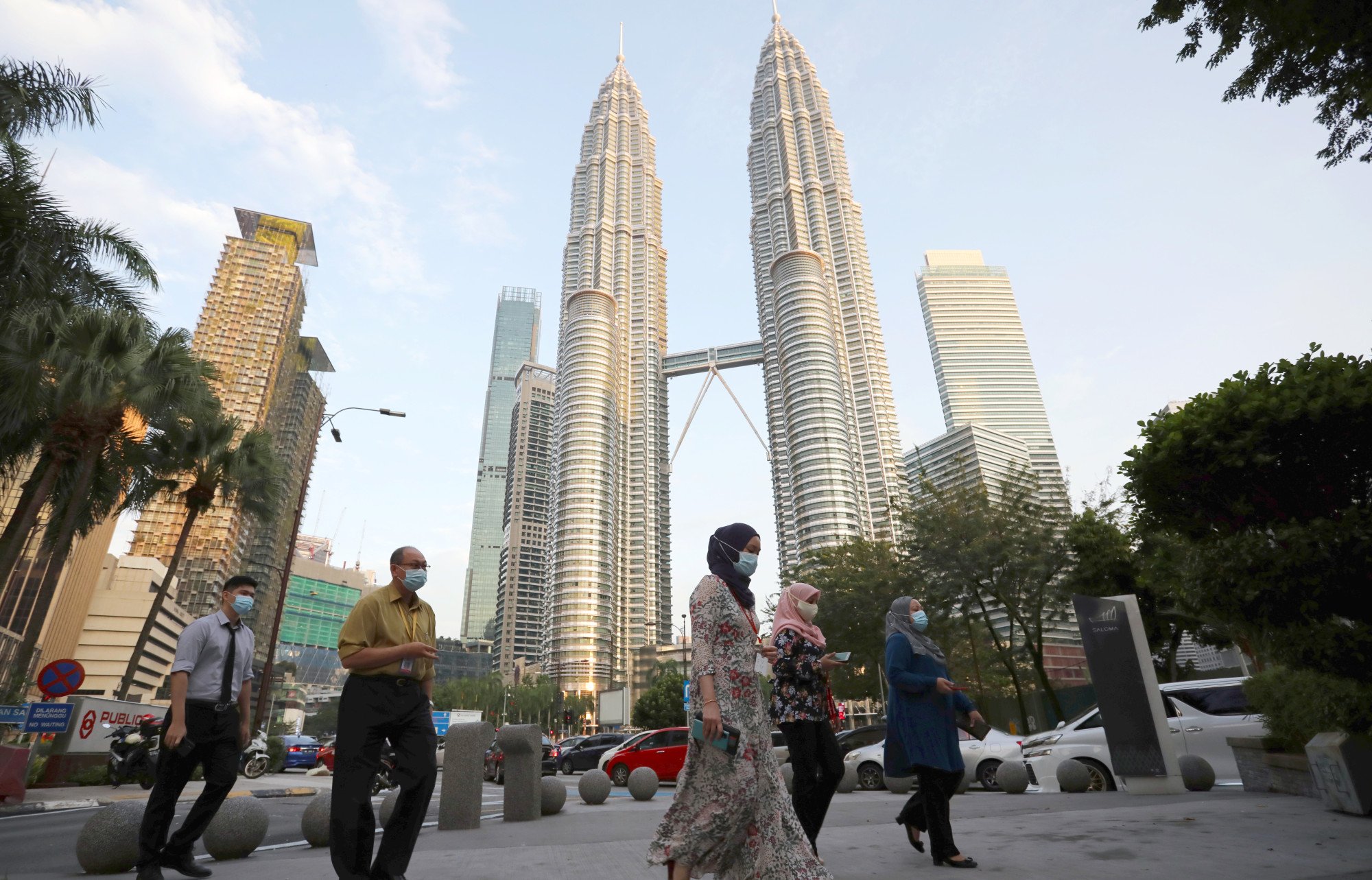 People cross a street in front of Petronas Twin Towers in Kuala Lumpur, Malaysia, on November 5, 2020. Photo: Reuters