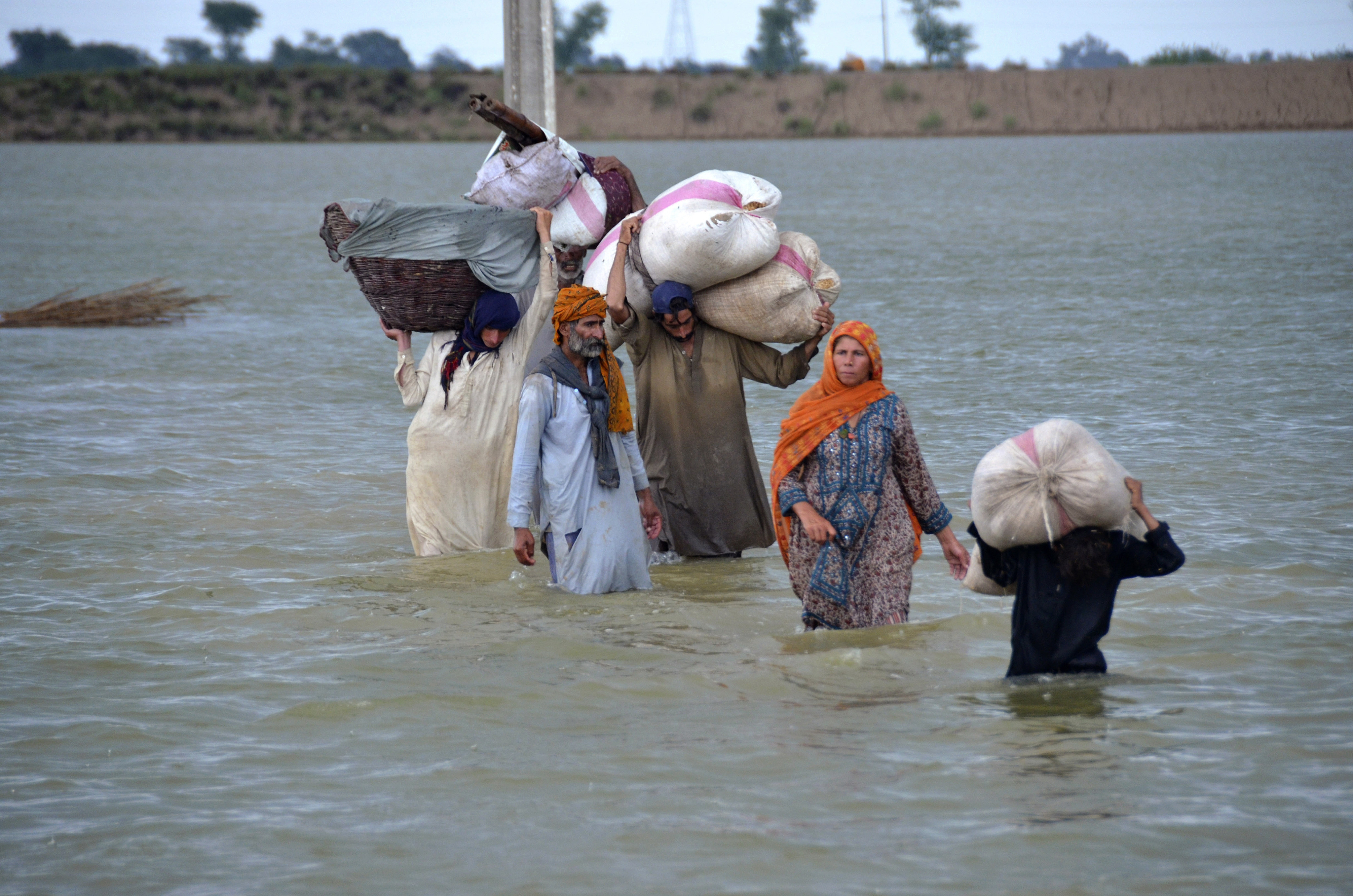 A displaced family wades through a flooded area after heavy rainfall, in Pakistan’s southwestern Baluchistan province. Photo: AP/File