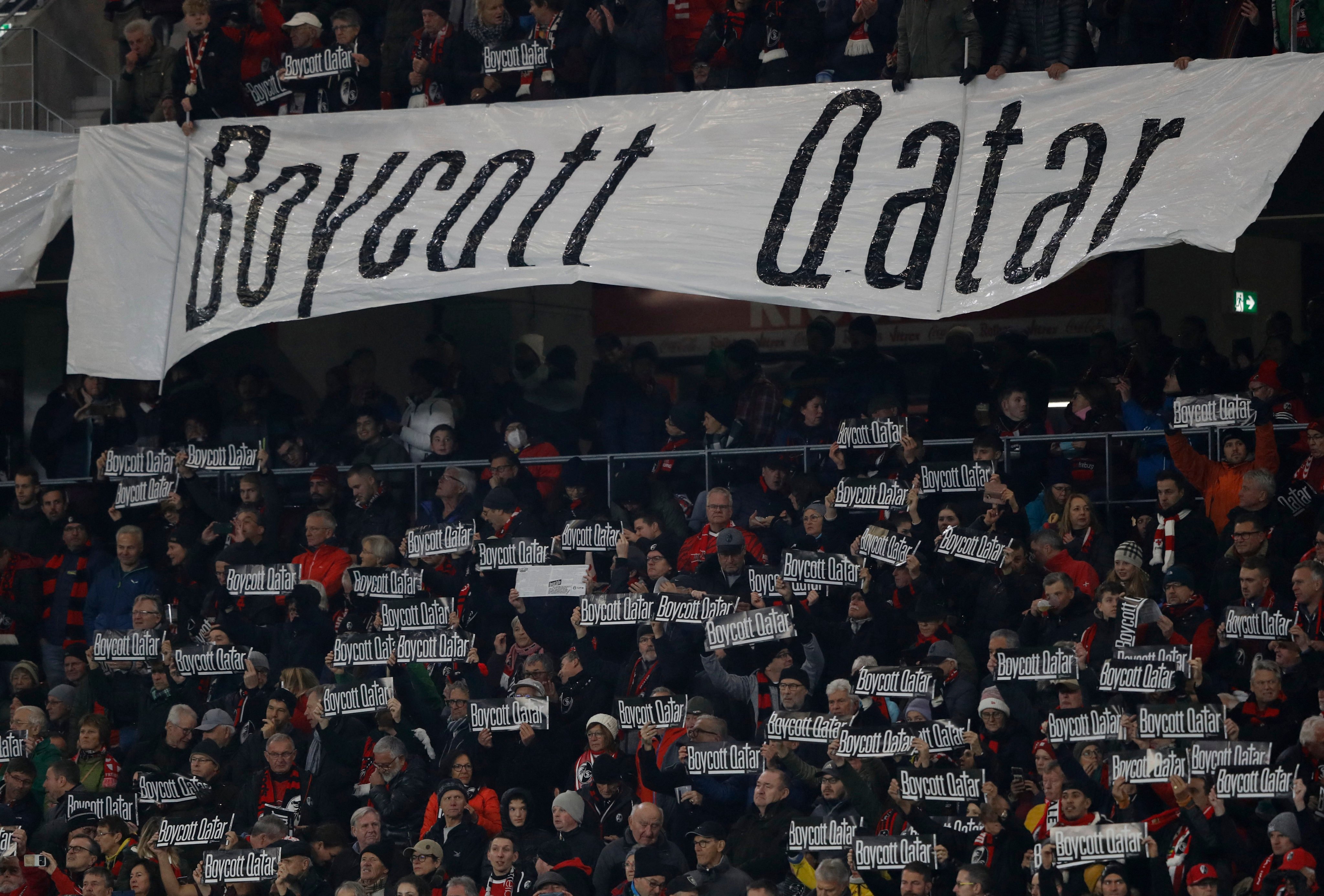 Freiburg fans hold signs also in reference to the Qatar World Cup before a match. Photo: Reuters