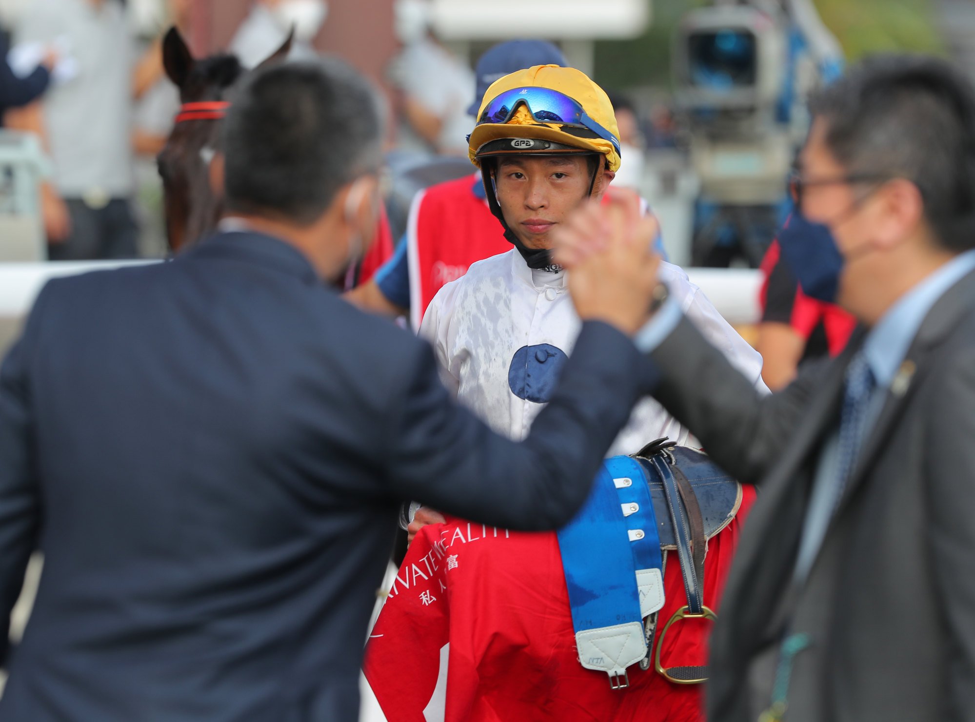 Jockey Vincent Ho watches on as trainer Francis Lui shakes hands with Golden Sixty’s owner Stanley Chan.