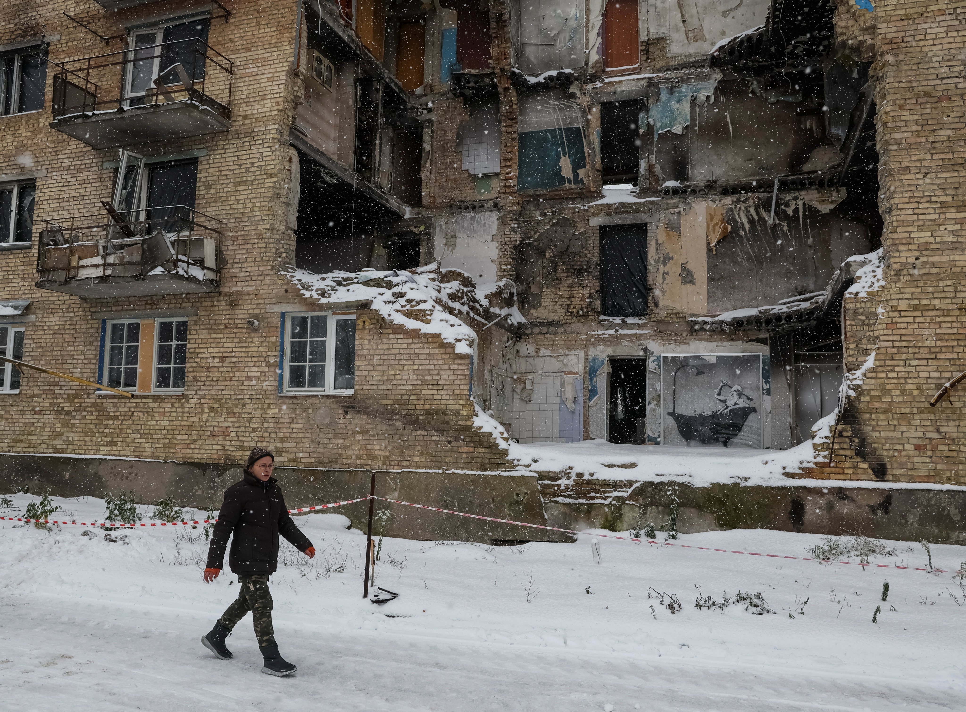 A local resident walks past a destroyed building in the Ukrainian village of Horenka on November 19. Photo: Reuters