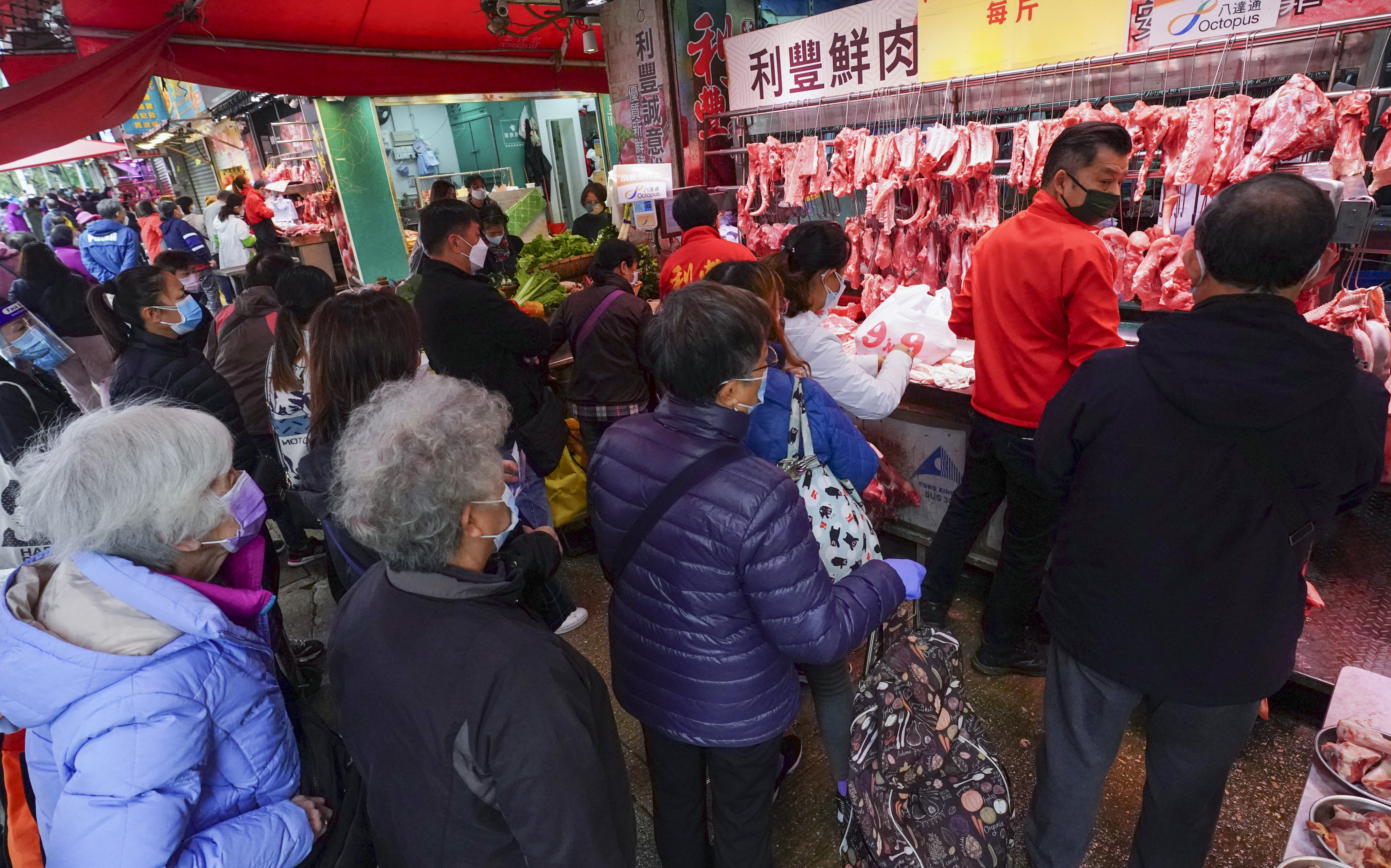 People queue up to buy meat at a wet market on February 25. Photo: Felix Wong