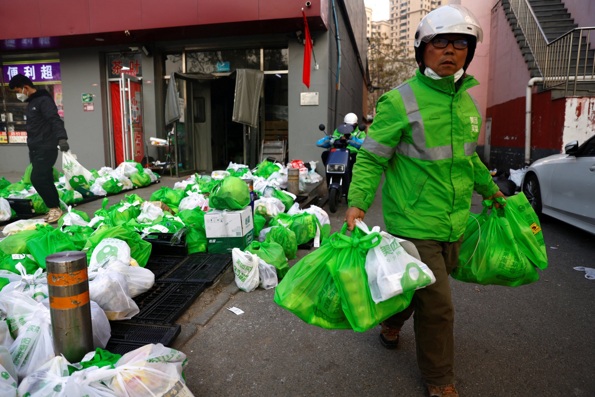 A delivery worker in Beijing picks up goods at a logistics station of an online grocery platform by Meituan. Photo: Reuters