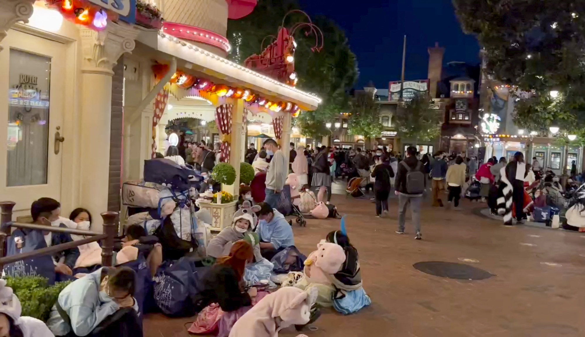 People sit inside the Shanghai Disney Resort in Shanghai on October 31, 2022, when thousands of visitors were held in the park for testing amid a Covid-19 outbreak. Image: Screen grab from a video obtained by Reuters.