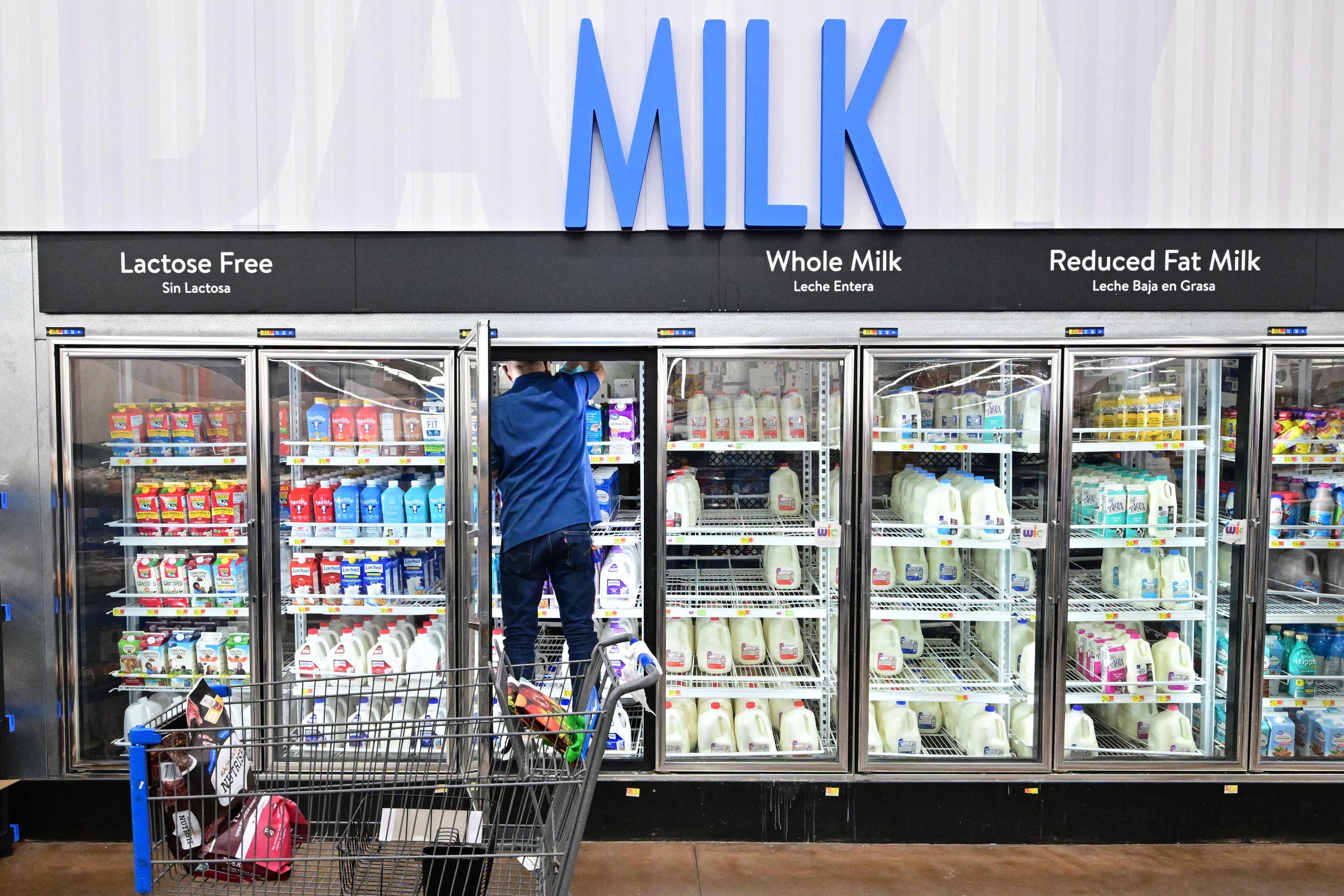 A man climbs into the fridge for milk at a Walmart store in Rosemead, California, on November 22. Retailers are hoping American consumers will keep spending. Photo: AFP 