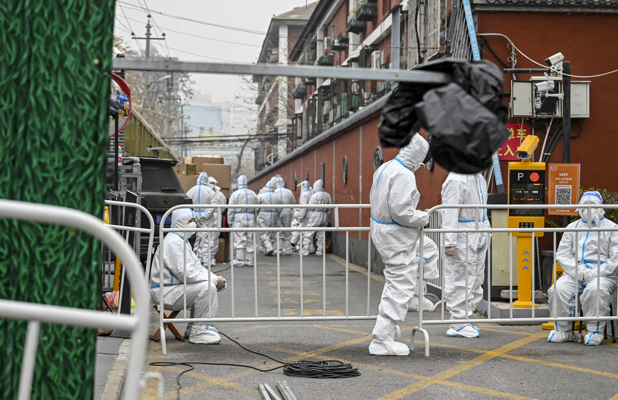 Security guards in personal protective equipment at a residential compound in Beijing after it was locked down to control the spread of Covid-19. Photo: AFP