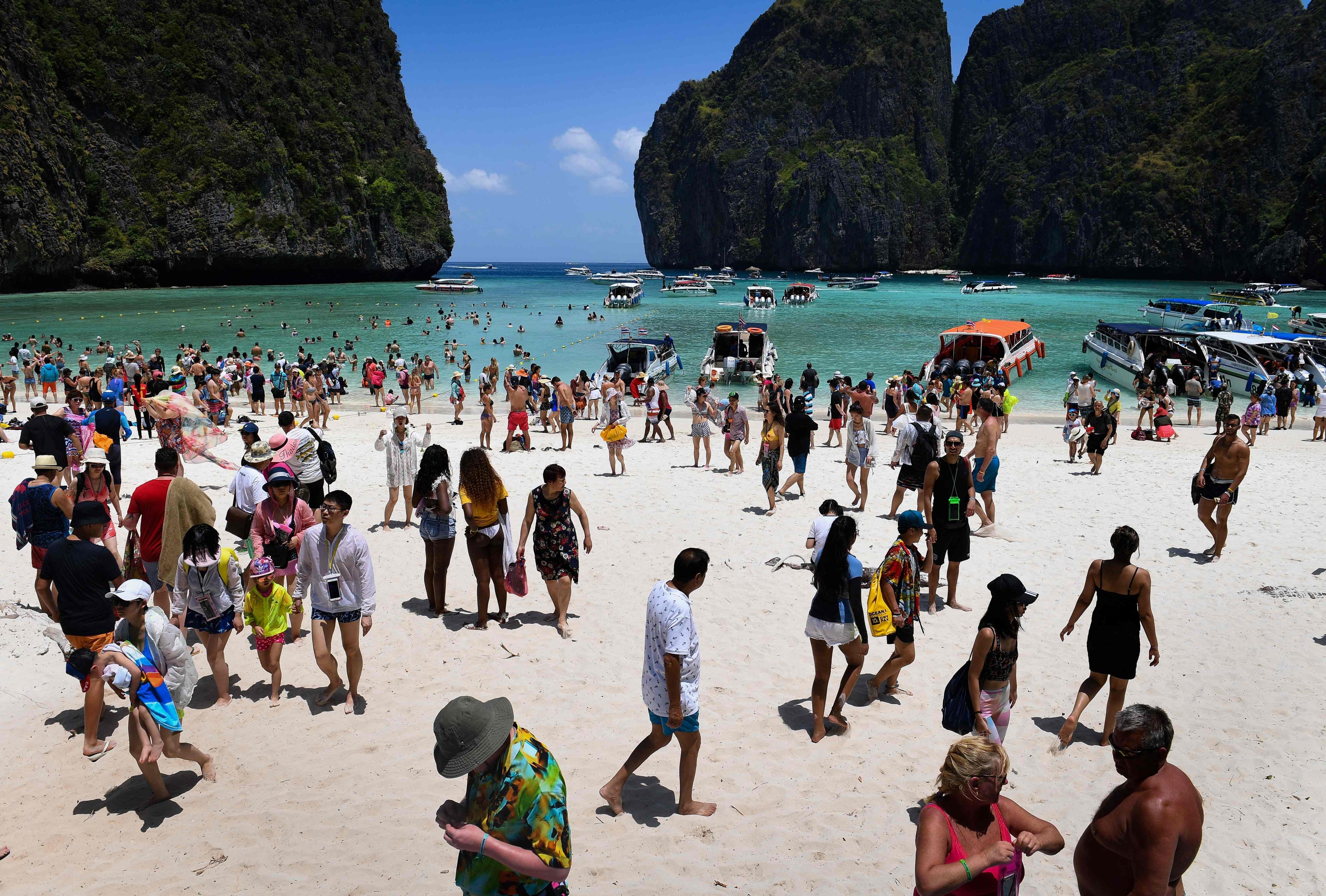 (FILES) In this file photo taken on April 9, 2018 shows a crowd of tourists on Maya Bay beach, on the southern Thai island of Koh Phi Phi. - More than two decades after Hollywood adventure drama &quot;The Beach&quot; was shot at Thailand&#39;s glittering Maya Bay, the Supreme Court in Bangkok on September 13, 2022 ordered the kingdom&#39;s forestry department to undertake further environmental rehabilitation work. (Photo by Lillian SUWANRUMPHA / AFP)