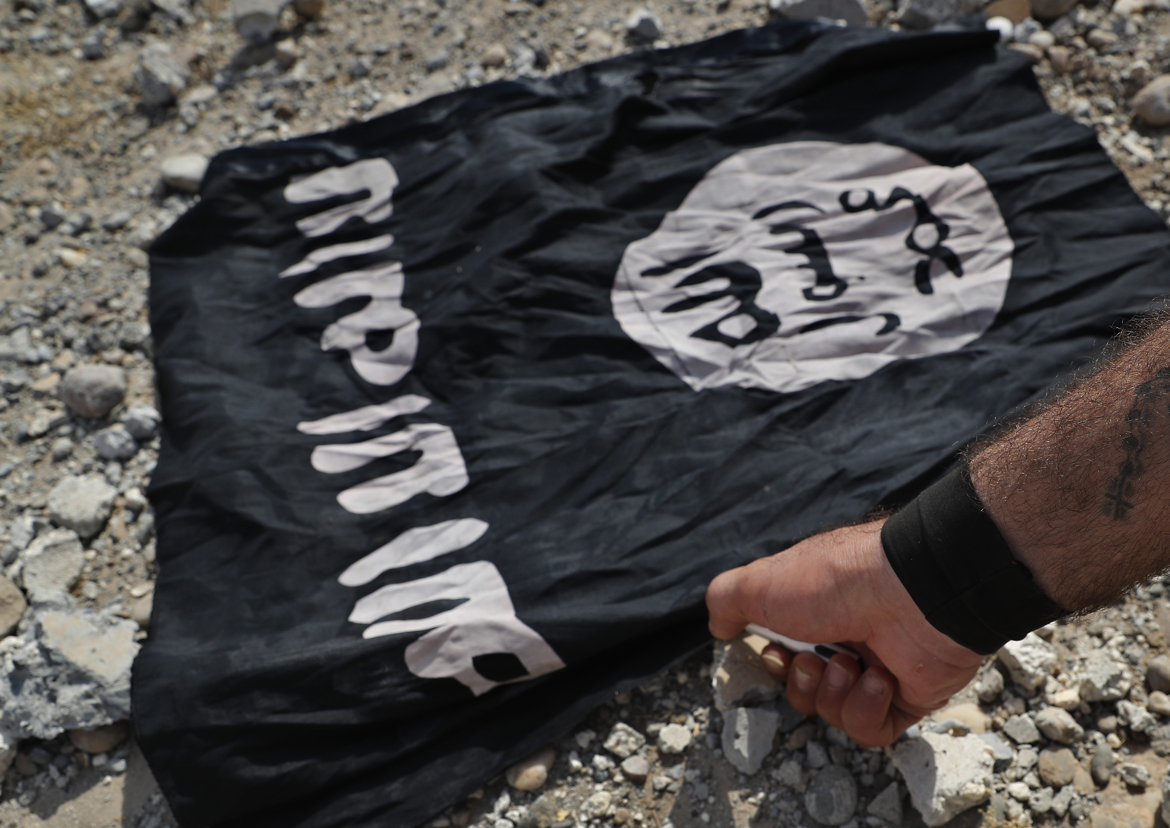 A fighter from the Christian Syriac militia that battles the Islamic State group under the banner of the US-backed Syrian Democratic Forces, burns an Isis flag on the front line in northeast Syria in July 2017. Photo: AP