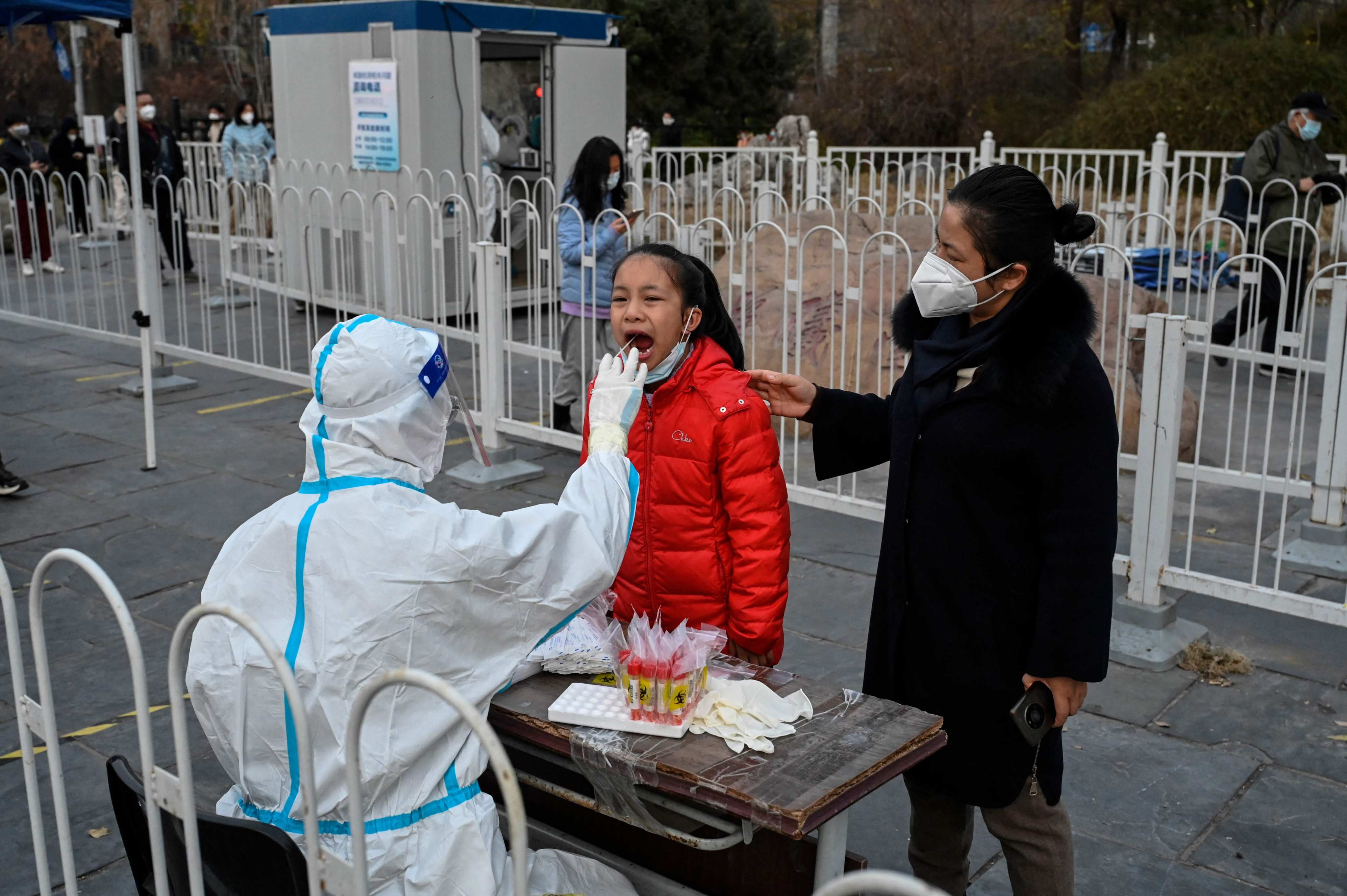 A health worker takes a swab sample from a girl at a testing station in Beijing. Photo: AFP