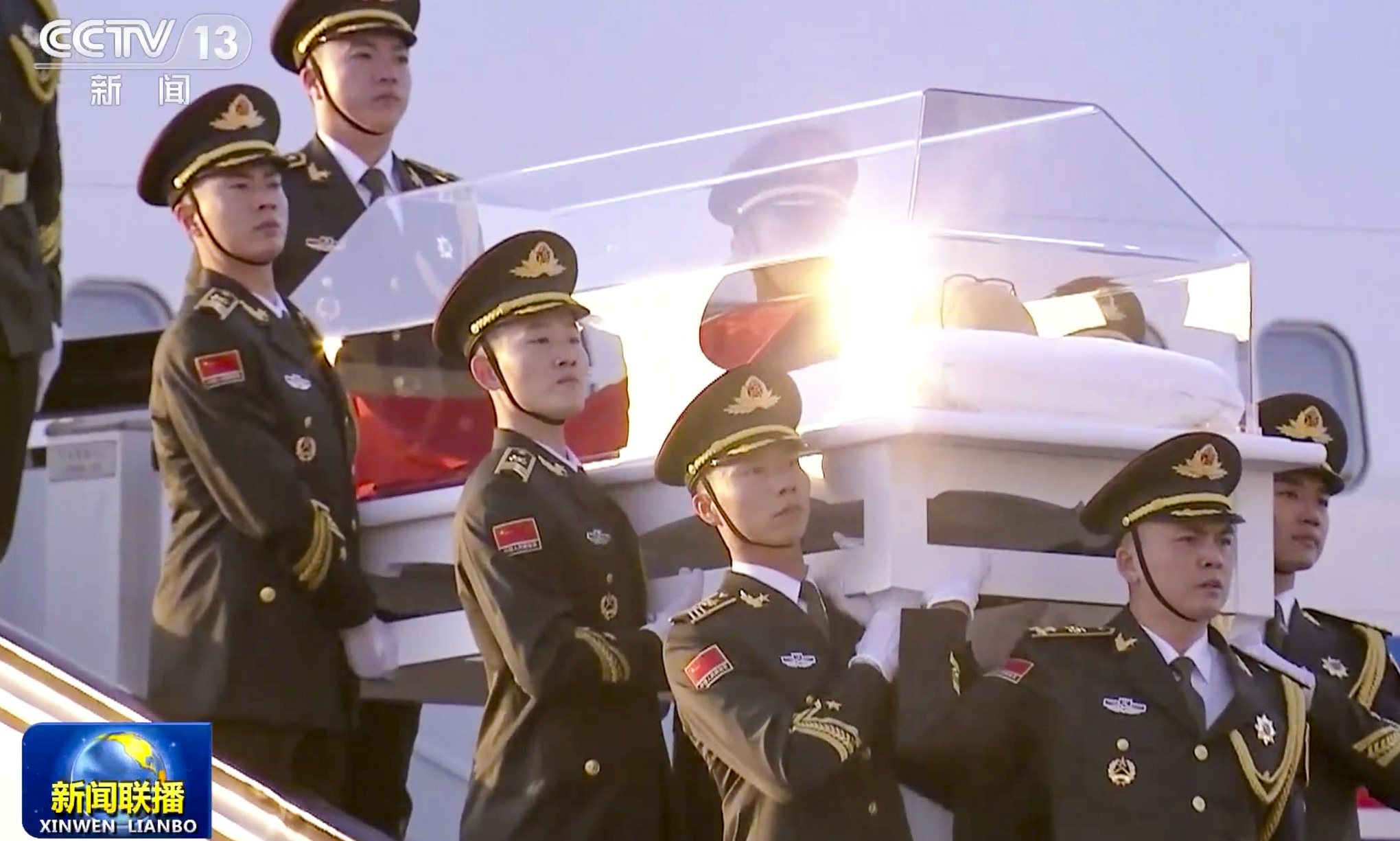 Troops carry Jiang Zemin’s casket down the steps from the plane that brought his body from Beijing. Photo: CCTV