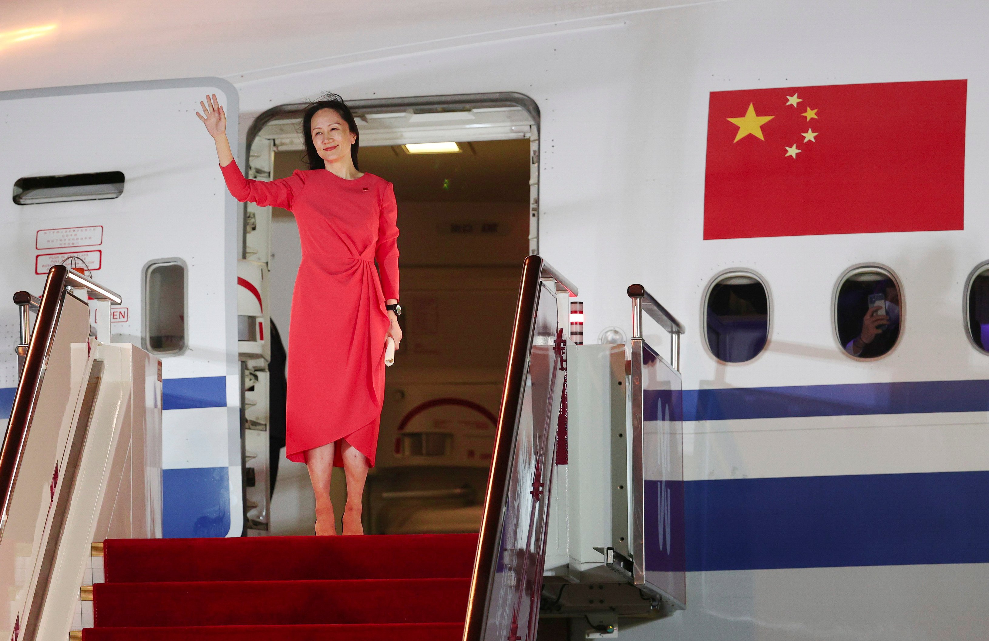 Meng Wanzhou waves at to a crowd as she deplanes in Shenzhen on September 25, 2021, after striking a deal with US prosecutors to end a case that had strained US-China relations. Photo: Xinhua