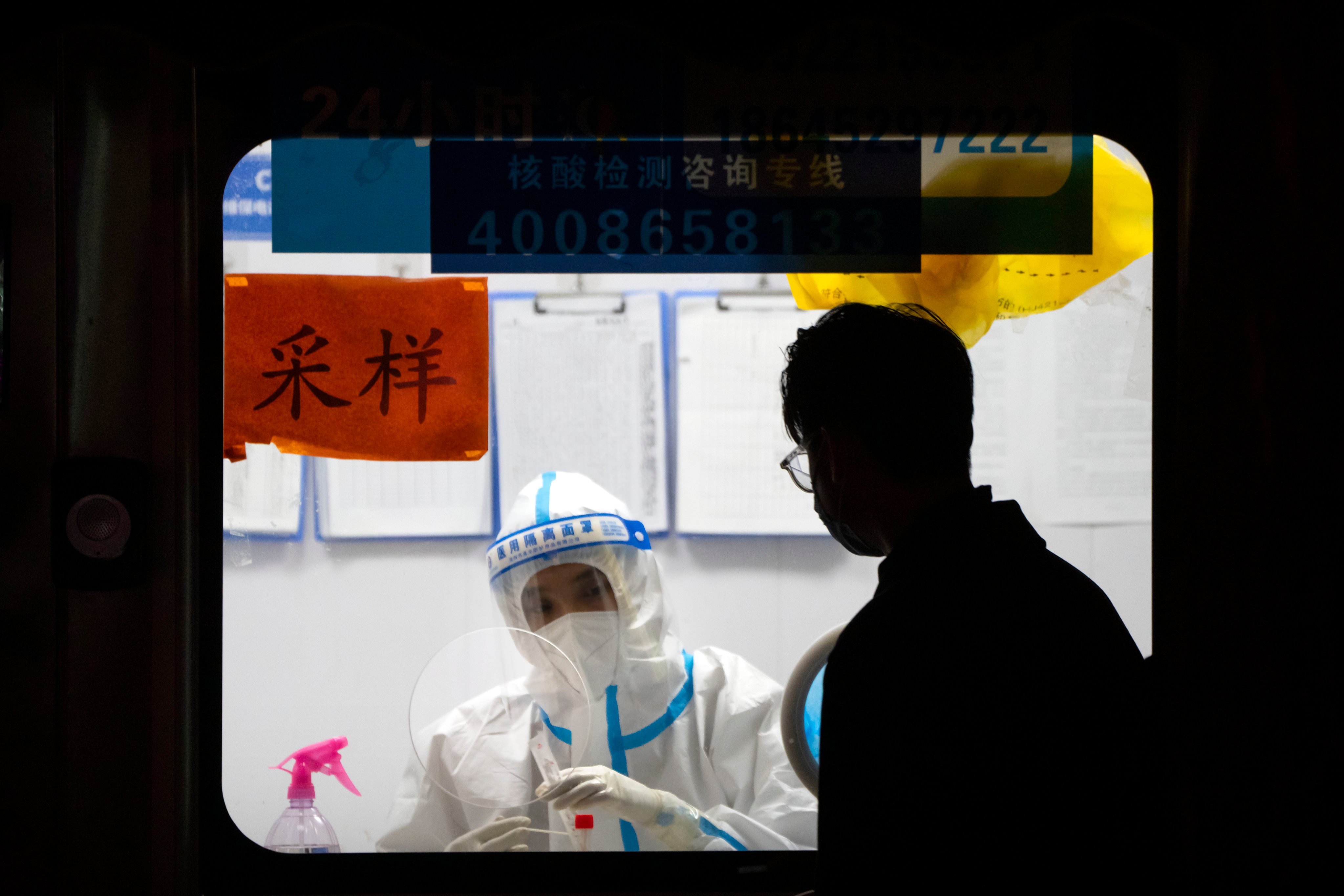 A worker in a protective suit waits to administer Covid-19 tests in Beijing in November. Photo: AP