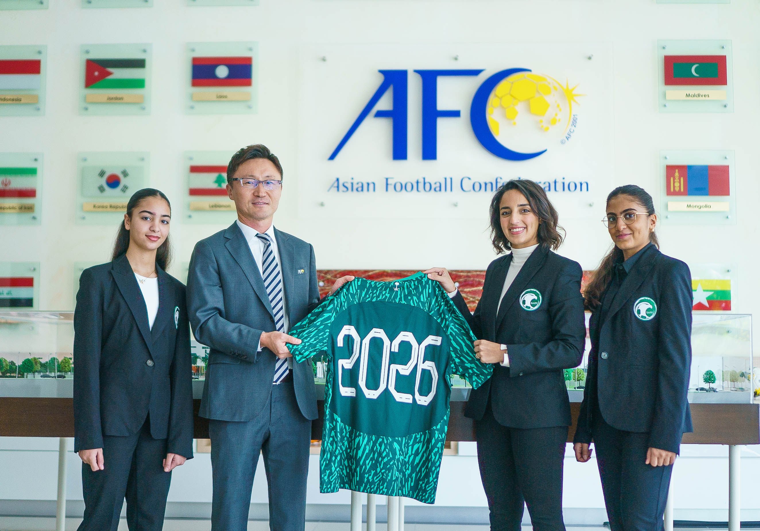 Saudi Arabia’s women’s national team assistant coach Dona Rajab (centre) presents a jersey to Jinho Yu, head of the Asian Cup office, as Marya Baghaffar (left) and Raghad Helmi look on. Photo: Handout
