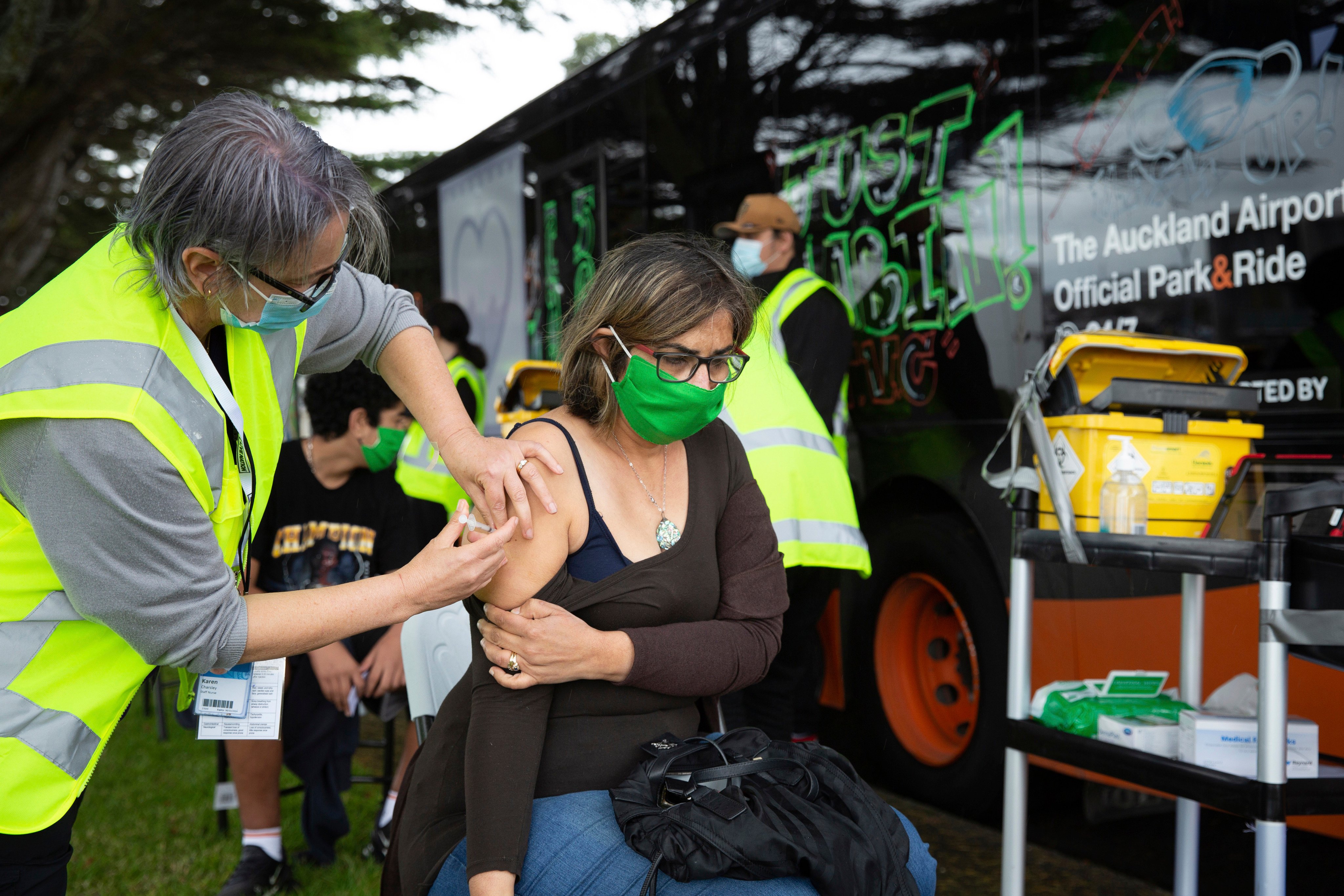 A health worker administers a Covid-19 vaccination to a woman in Auckland, New Zealand, last year. Photo: New Zealand Herald via AP