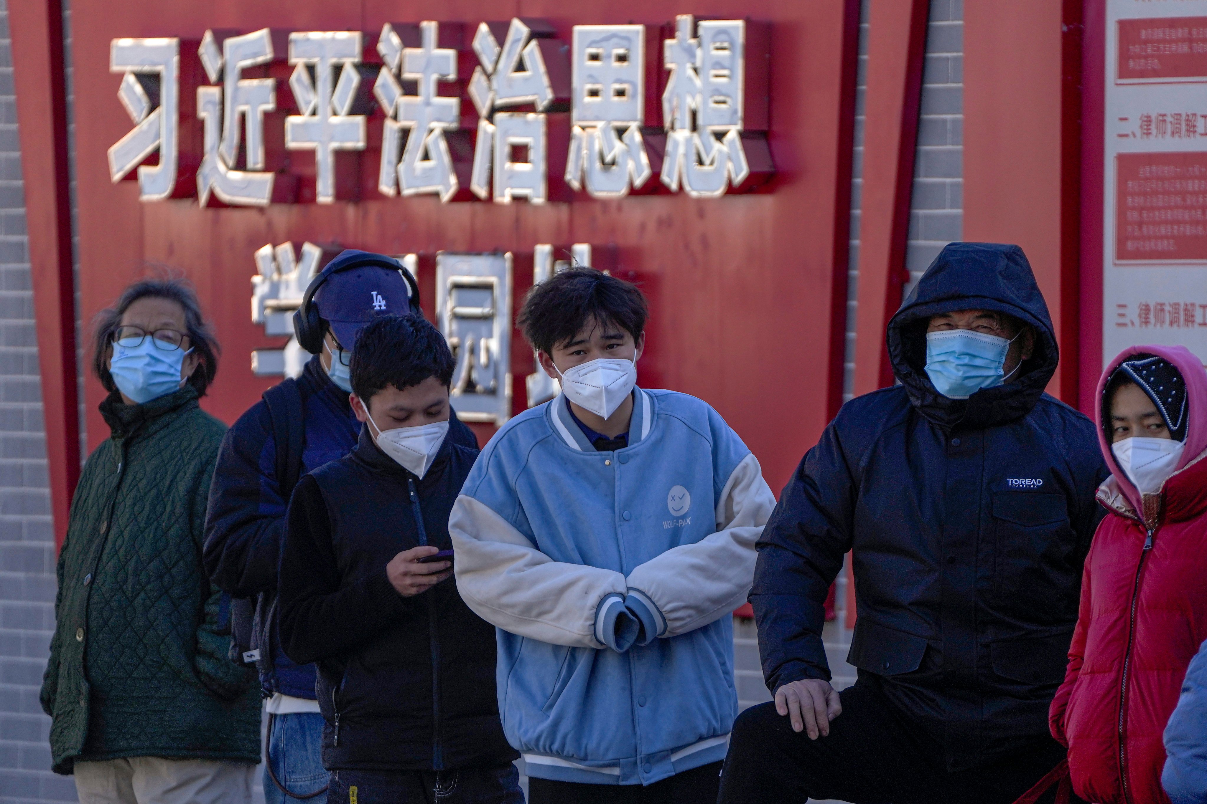 Residents wearing face masks wait in line for their routine Covid-19 tests in Beijing on Monday. Photo: AP Photo