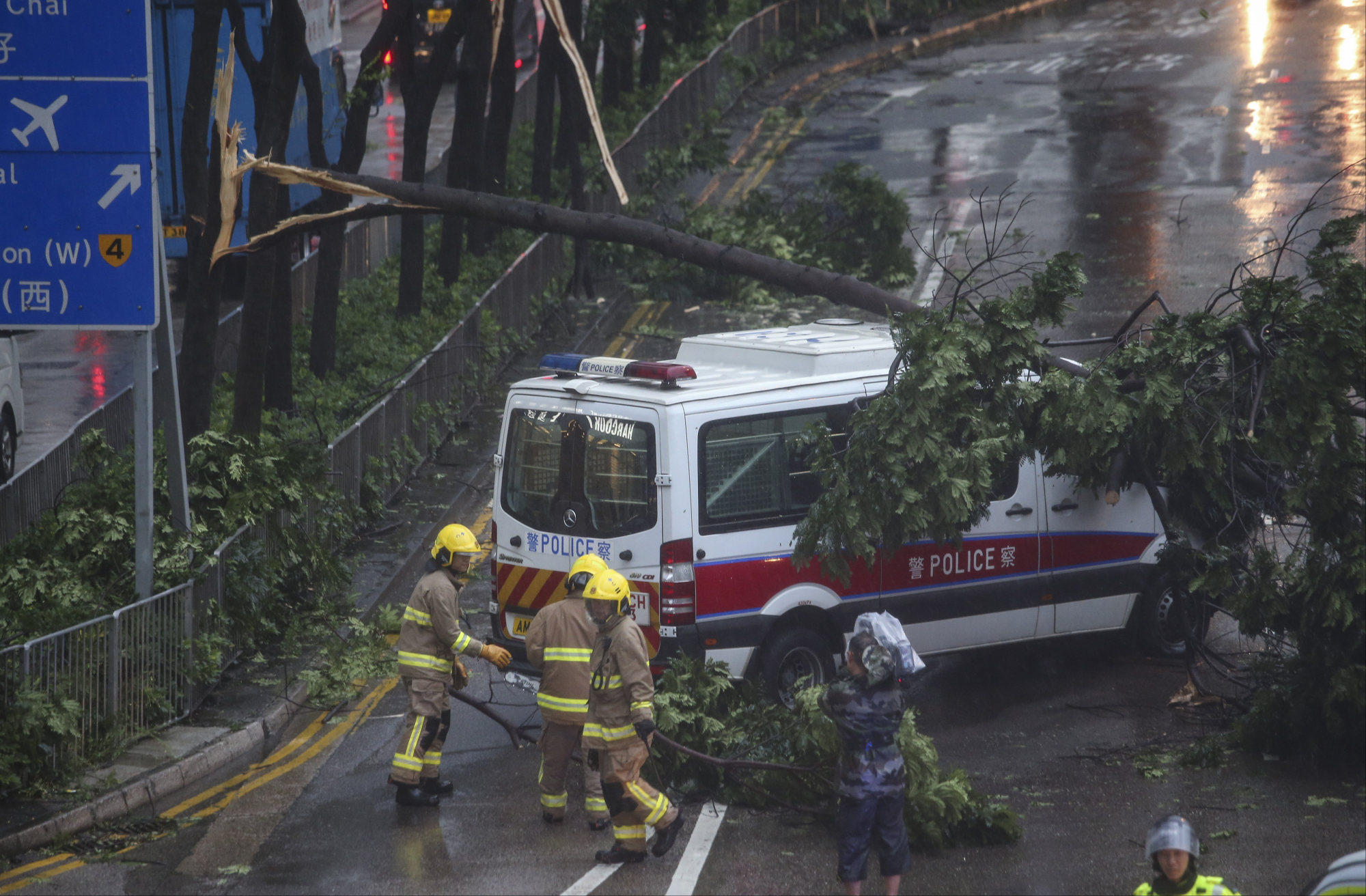 A tree limb sits on a police vehicle on Gloucester Road in Wan Chai as Typhoon Hato hits Hong Kong in 2017. Photo: David Wong