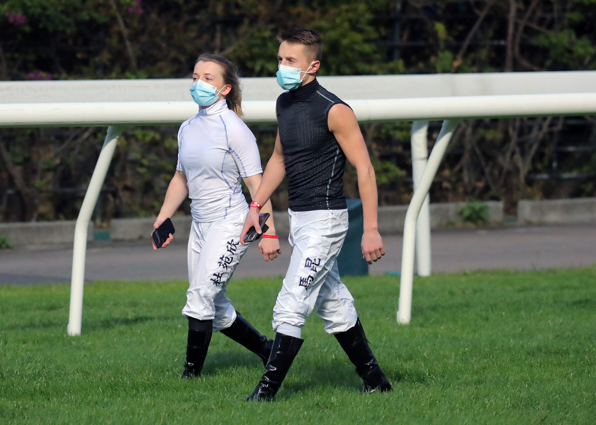 Hollie Doyle and husband Tom Marquand walk the Happy Valley turf.
