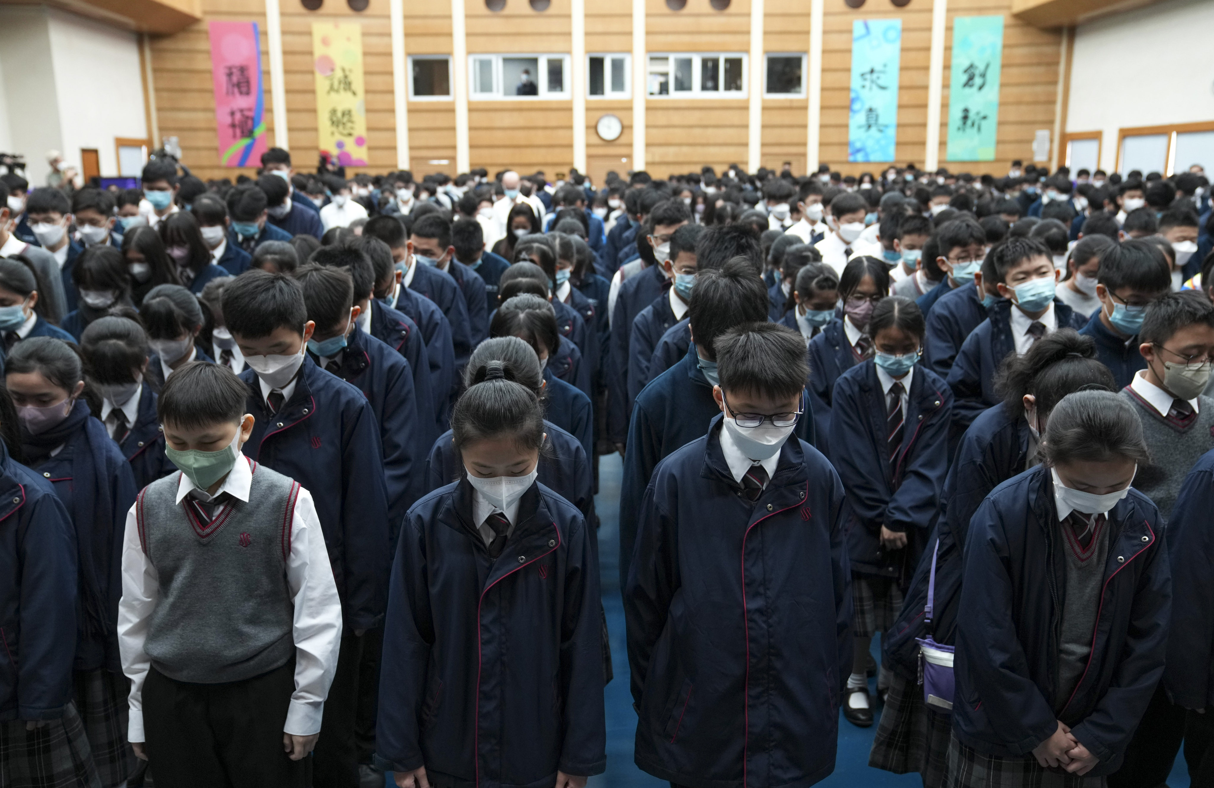 Scientia Secondary School students observing three minutes of silence before the live broadcast of the funeral service. Photo: Sam Tsang