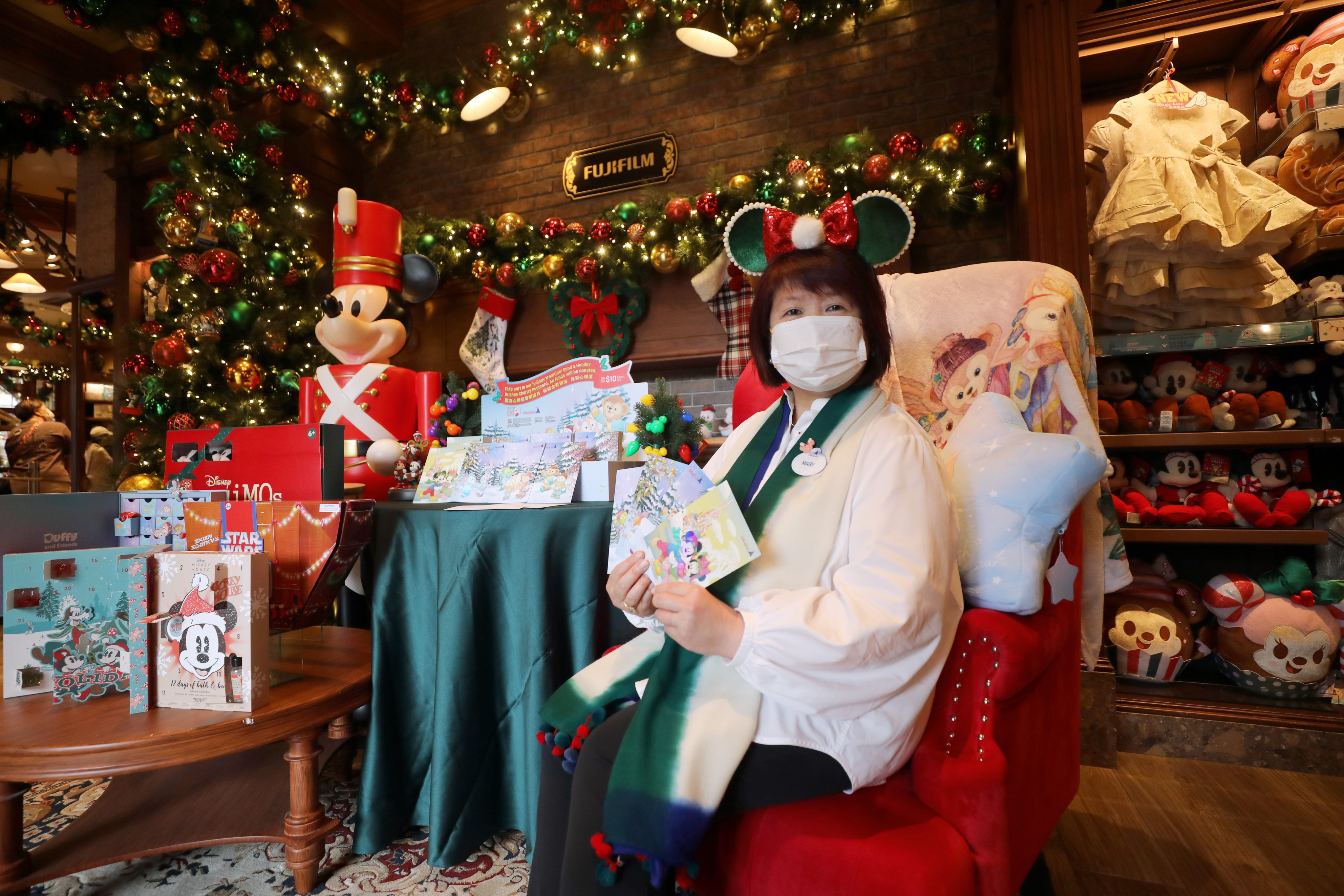Mary Lam, the director of merchandise at Hong Kong Disneyland Resort, shows off some of the charity postcards available to support Operation Santa Claus. Photo: Xiaomei Chen