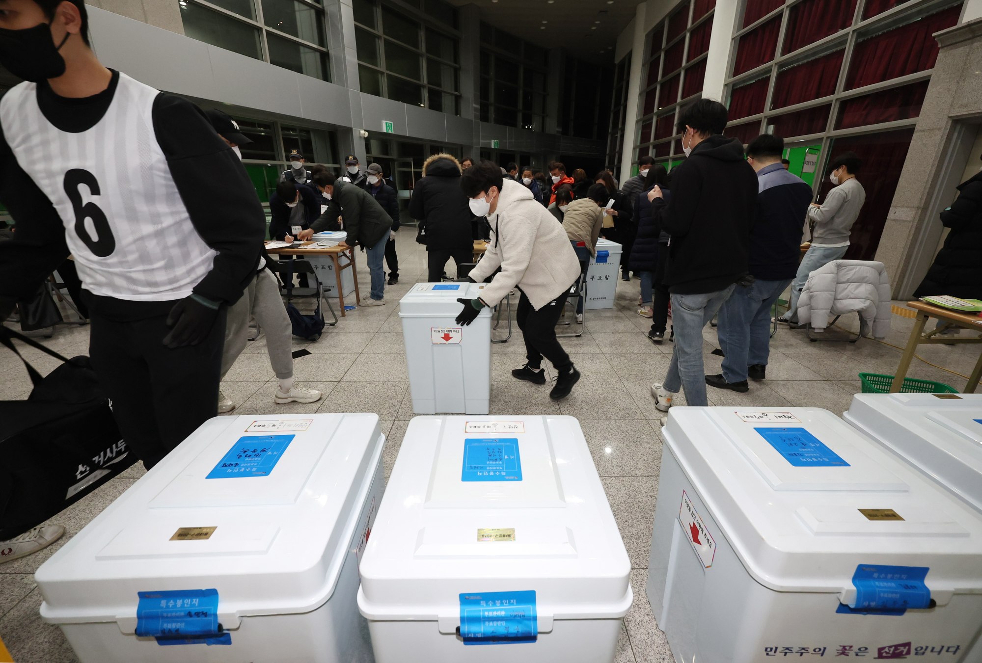 Officials move ballot boxes from polling stations to a ballot counting station in Seoul on March 9, 2022, after the conclusion of voting for the presidential election. Photo: EPA-EFE/Yonhap