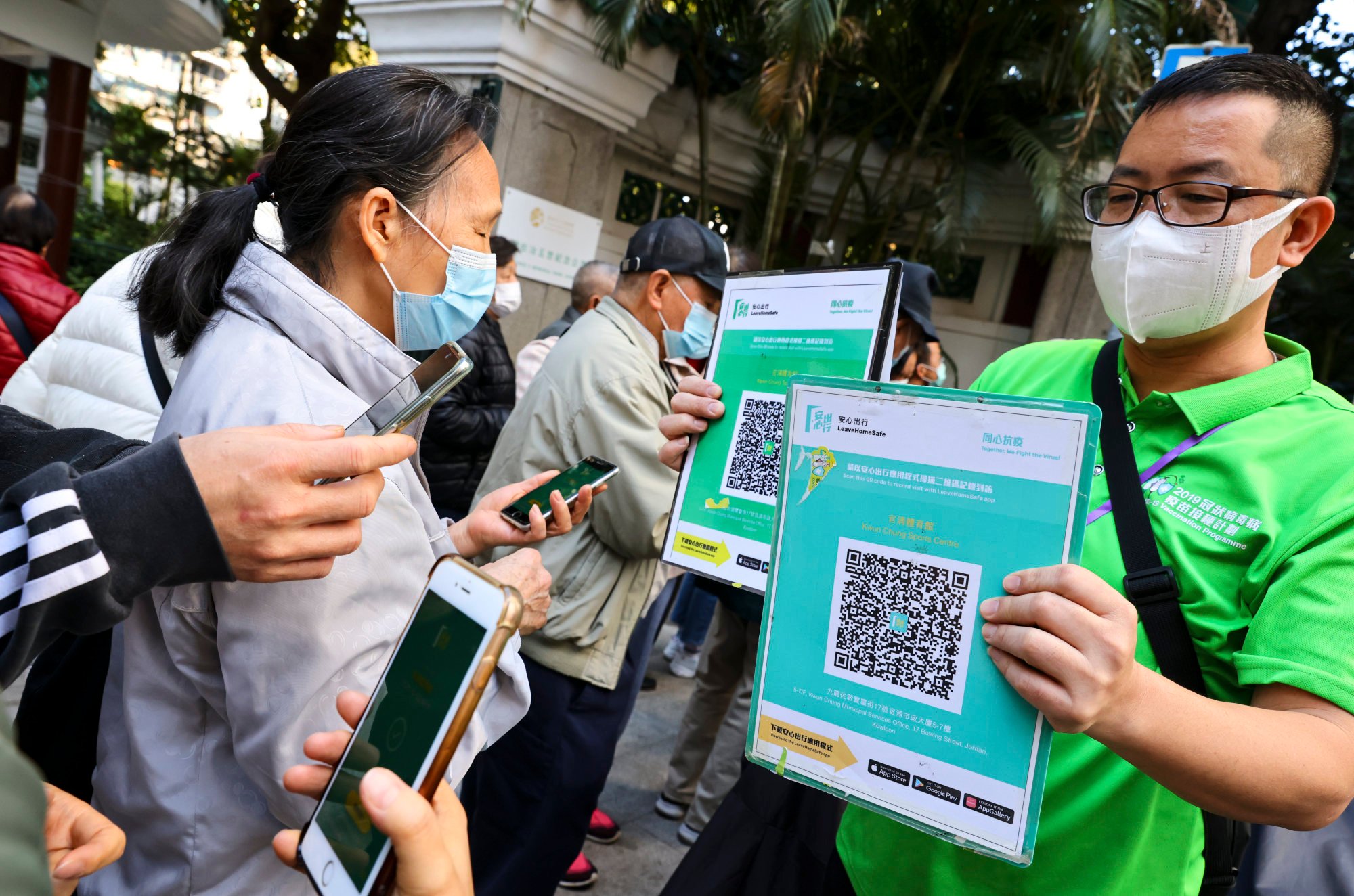 Staff at a community vaccination centre display a QR code for users to scan on their “Leave Home Safe” apps. Photo: Dickson Lee
