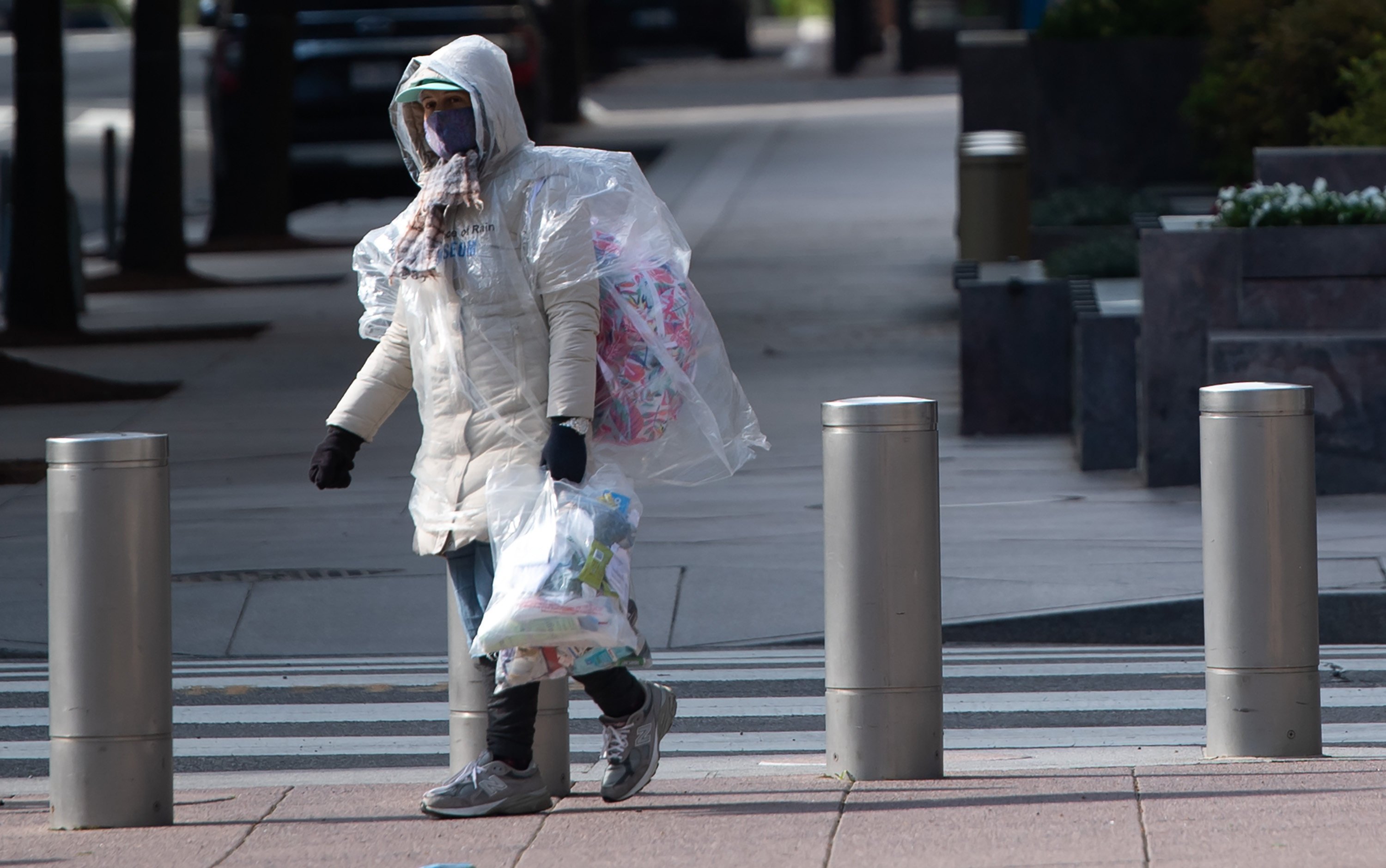 A person wrapped in plastic walks outside the headquarters of the International Monetary Fund during the onset of the Covid-19 pandemic in Washington on April 15, 2020. Photo: AFP