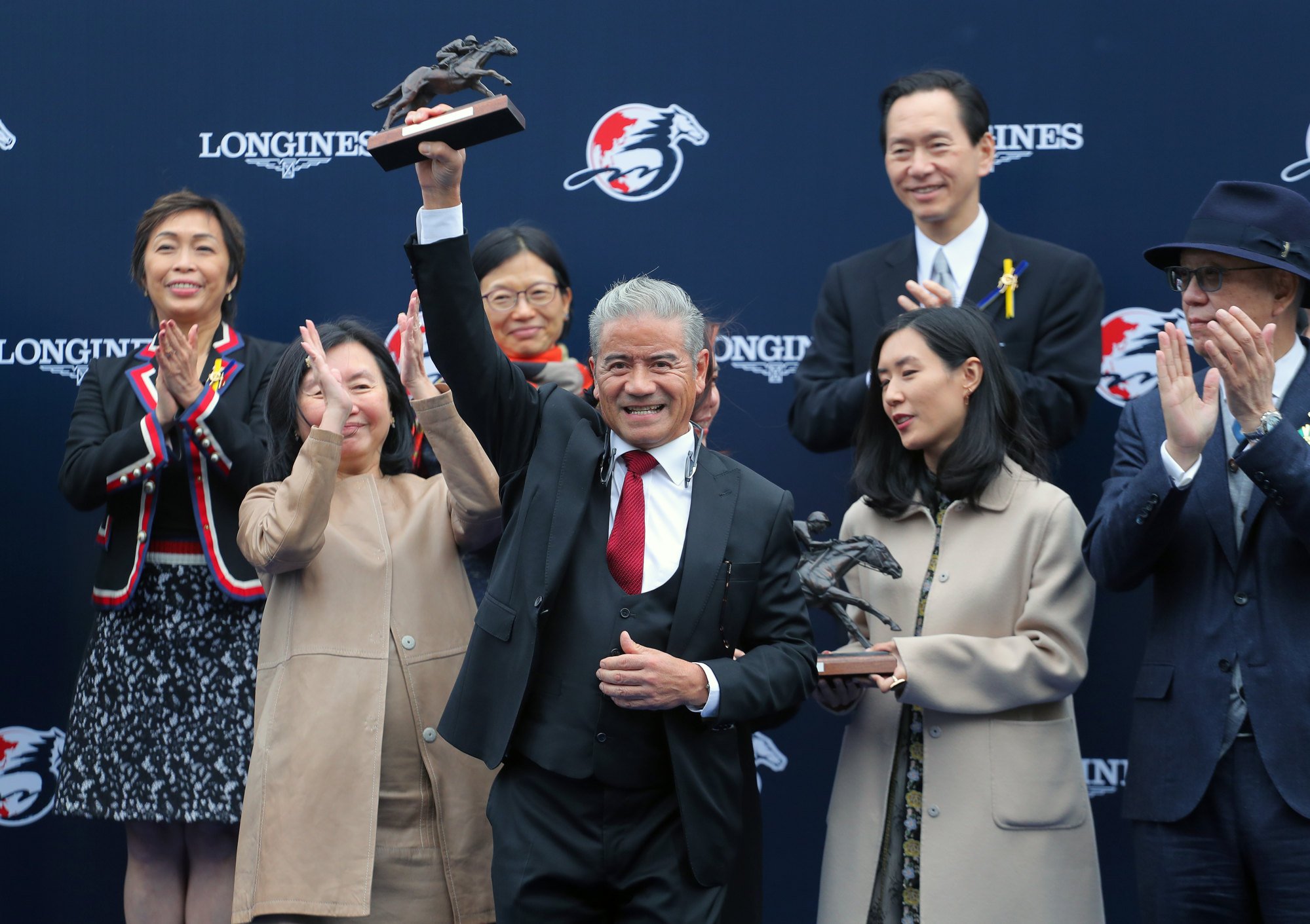 California Spangle’s handler, Tony Cruz, lifts the Hong Kong Mile winner’s trophy.