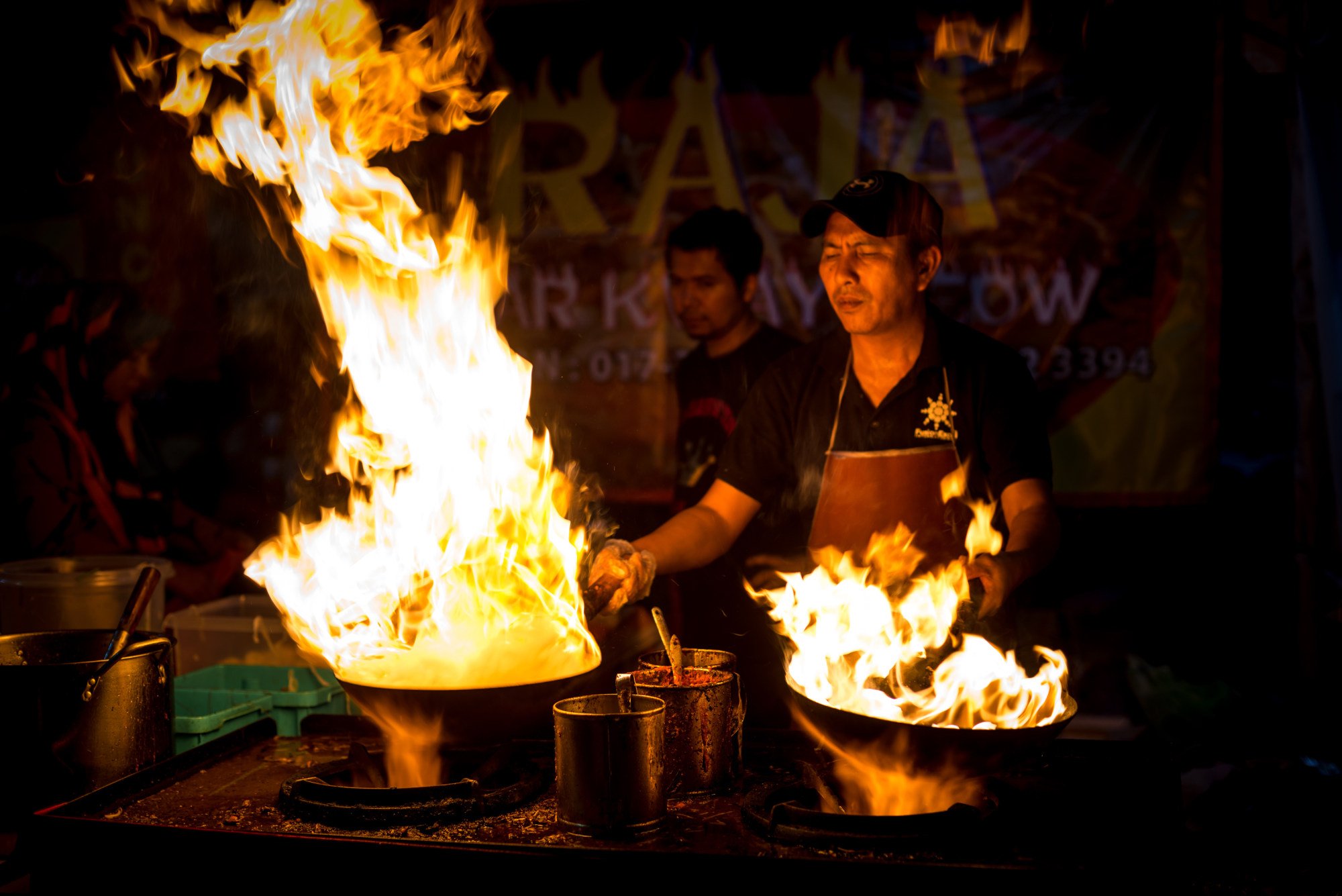 Char kuay teow, a spicy rice noodle dish with prawns, cooks at a roadside stall in Malaysia. Photo: Shutterstock