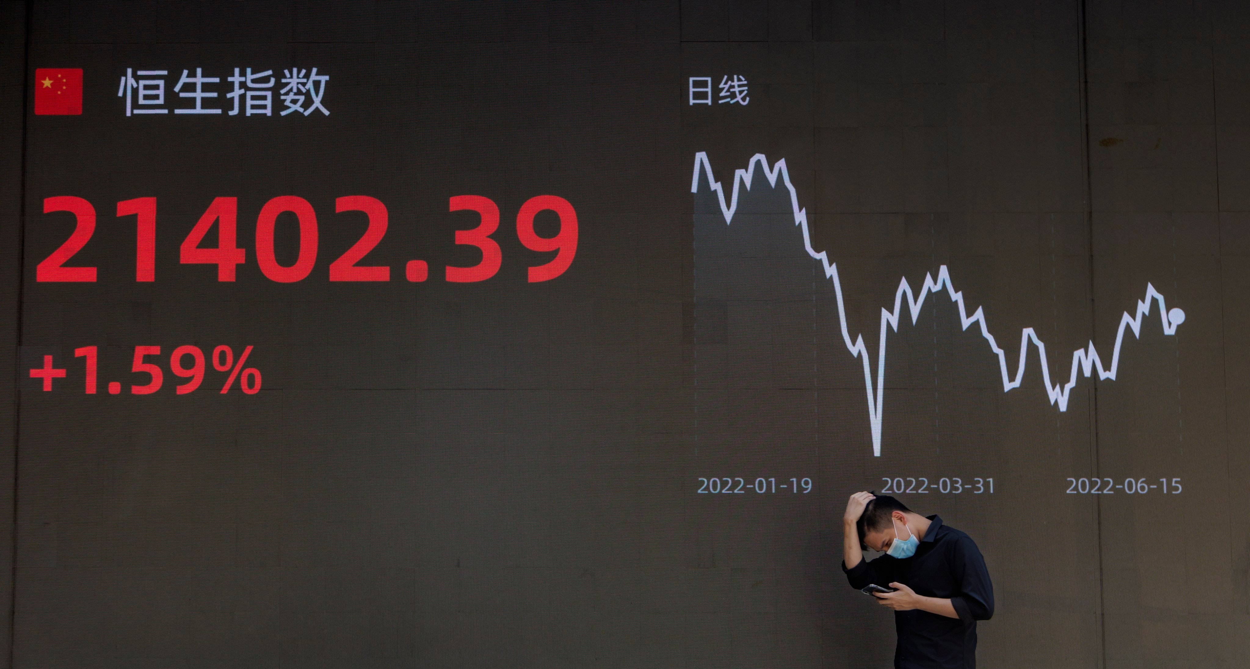 A man stands in front of a screen showing the latest economy and stock exchange updates in Shanghai on June 15. The past year has been nearly a perfect storm for China and other Asian economies, but shifting winds could turn in their favour in 2023. Photo: EPA-EFE