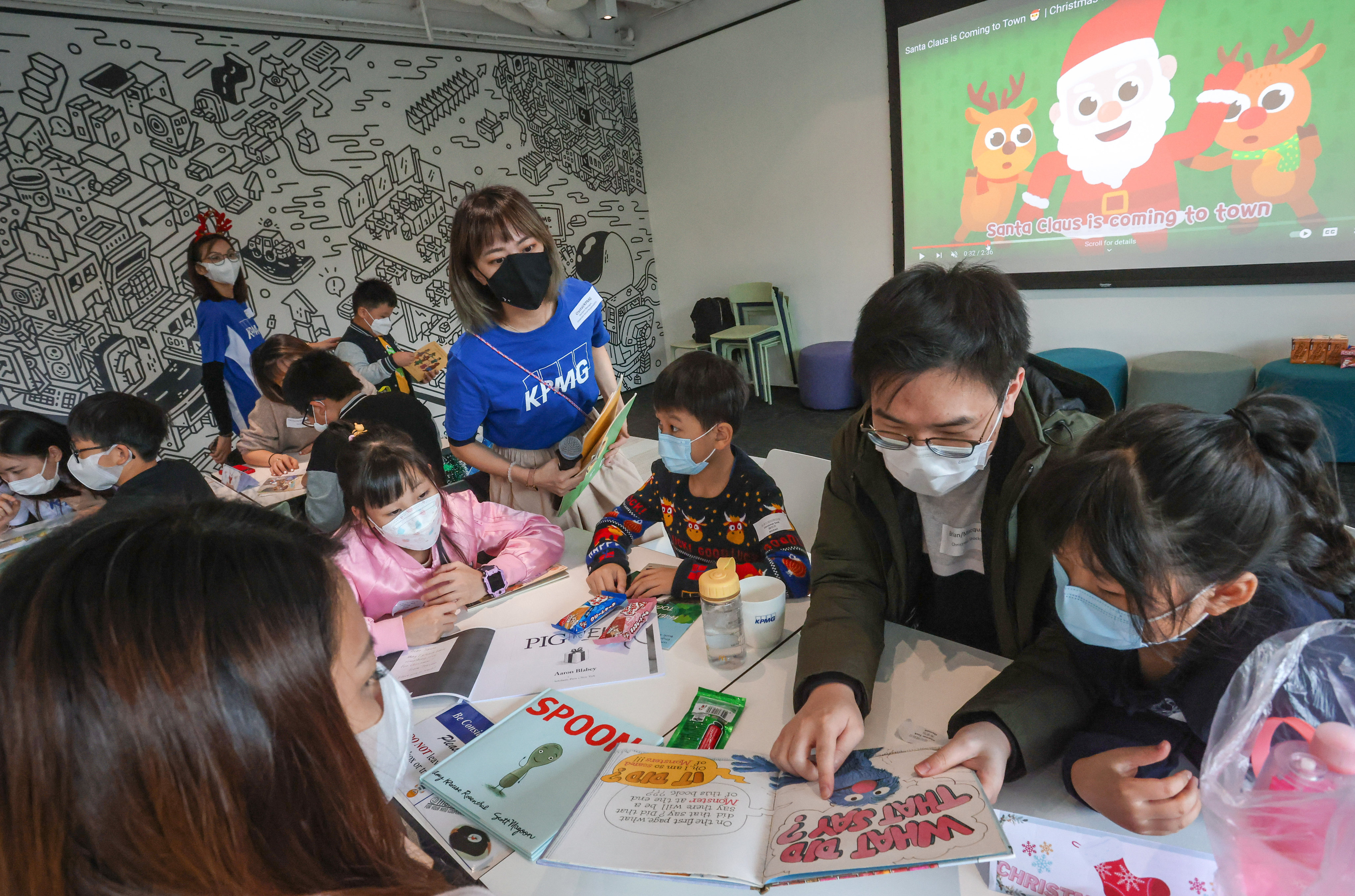 KMPG China volunteers read English stories to children. Photo: Jonathan Wong