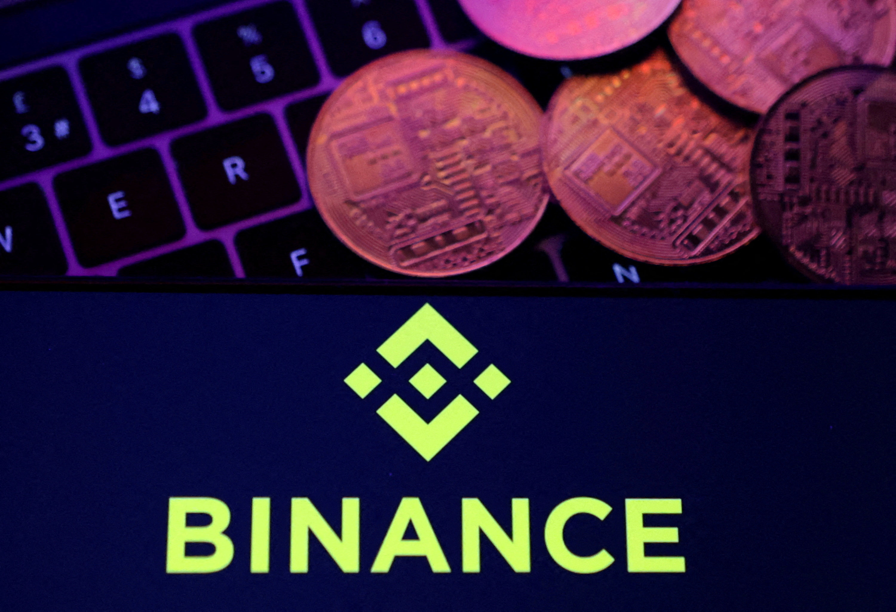 The Binance logo displayed on a smartphone with representations of cryptocurrencies placed on a keyboard in this illustration taken November 8, 2022. Photo: Reuters