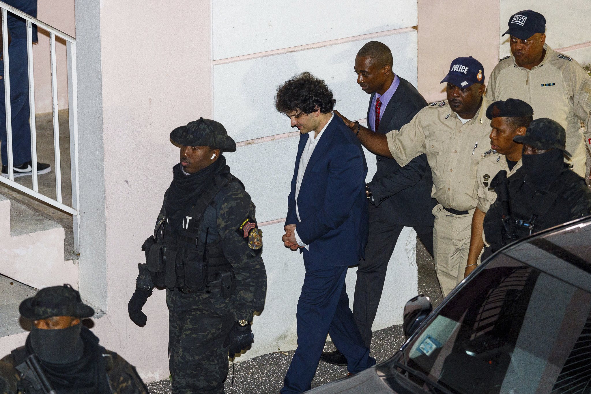 Samuel Bankman-Fried, centre, is escorted out of the Magistrate Court building the day after his arrest in Nassau, Bahamas, on December 13, 2022. Photo: AP