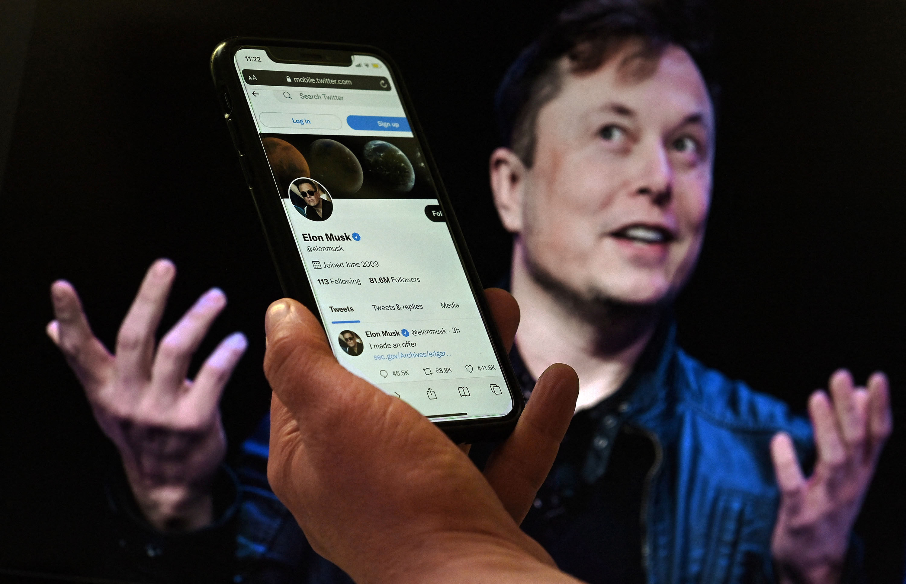 A phone displays the Twitter account of Elon Musk with an image of him displayed in the background in this photo taken on December 15, 2022. Photo: AFP