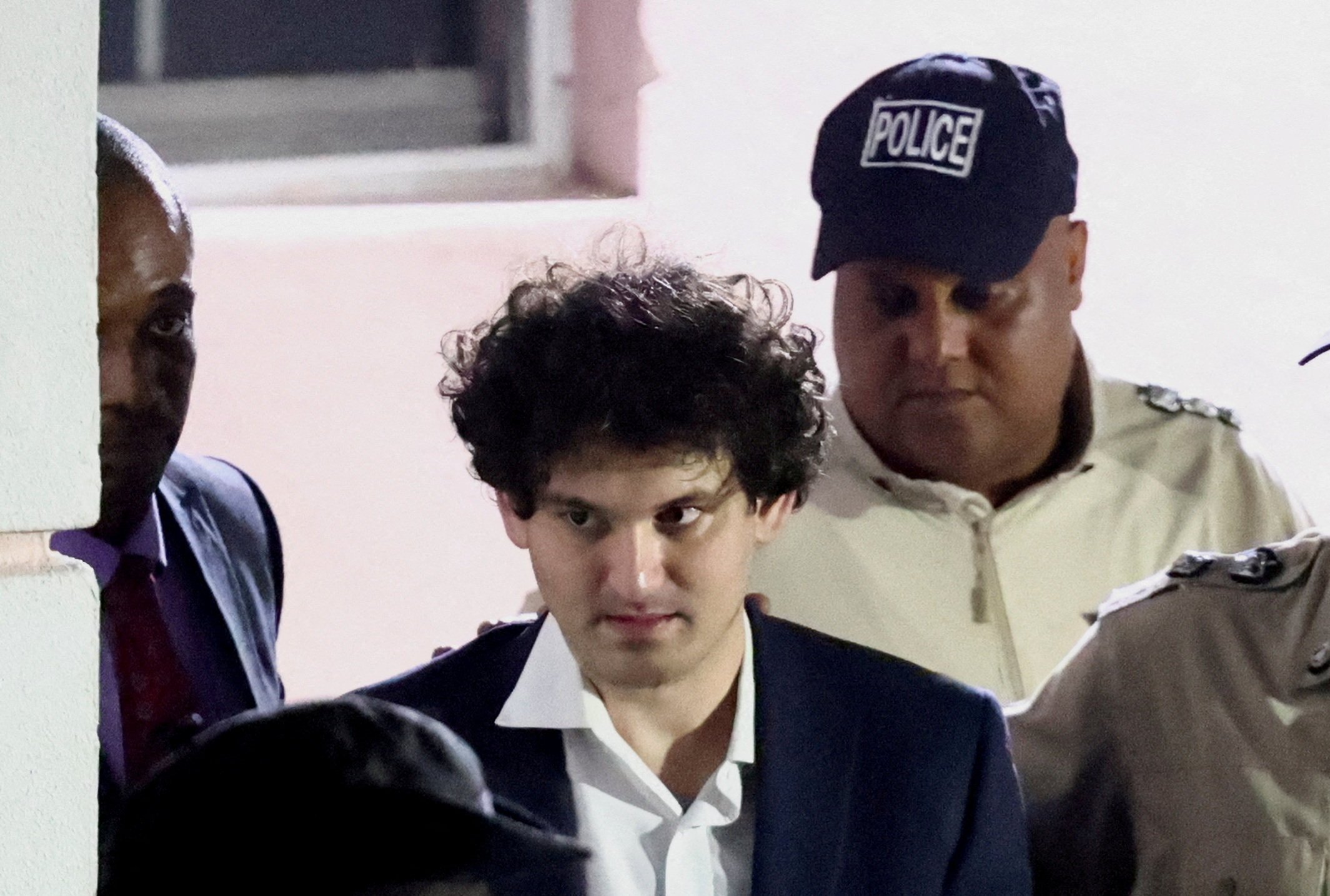 Sam Bankman-Fried is escorted out of the Magistrate Court building after his arrest in Nassau, Bahamas on December 13. Photo: Reuters