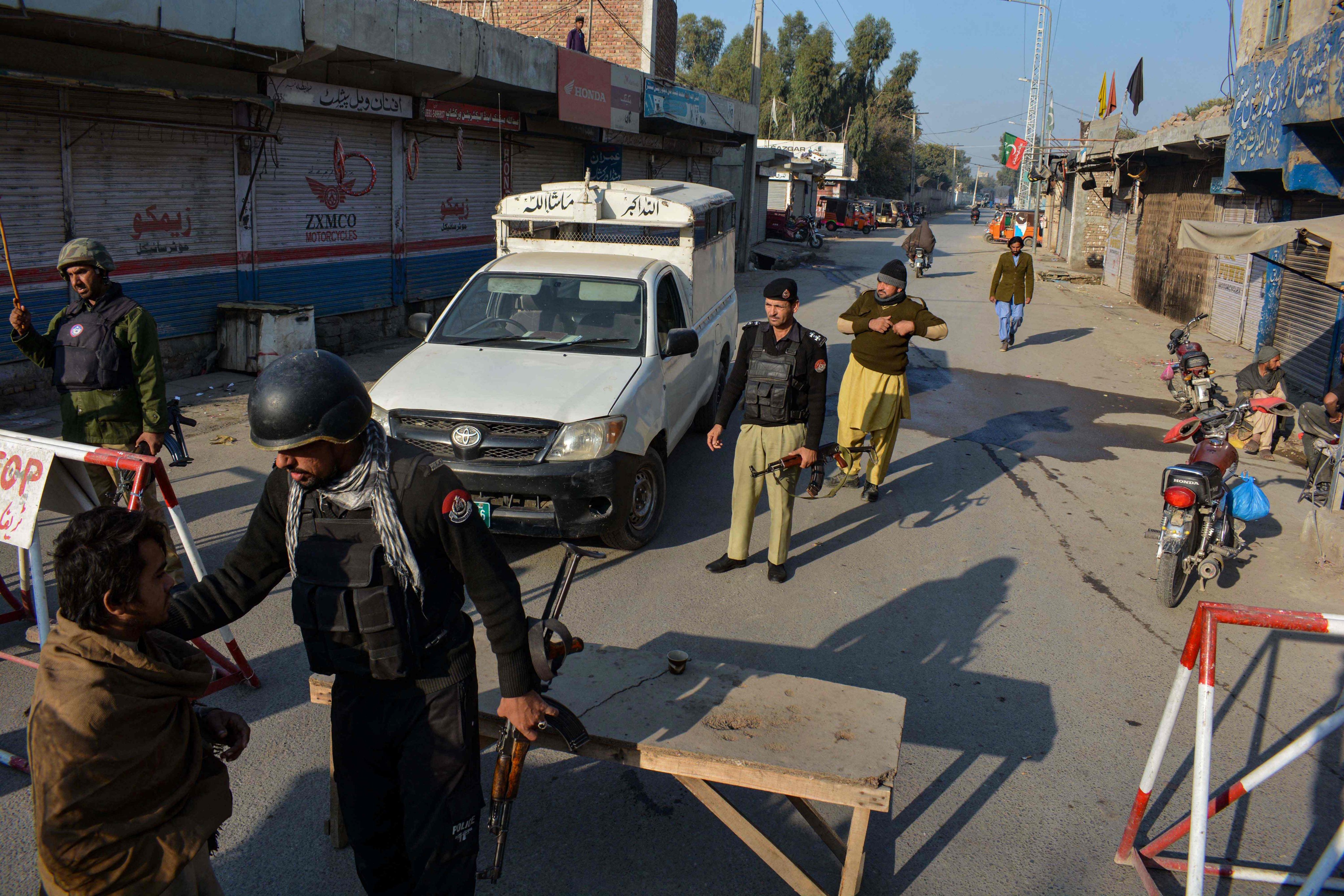 Police stand guard along a road they blocked after Taliban militants seized a police station in Bannu on December 19, 2022. Photo: AFP