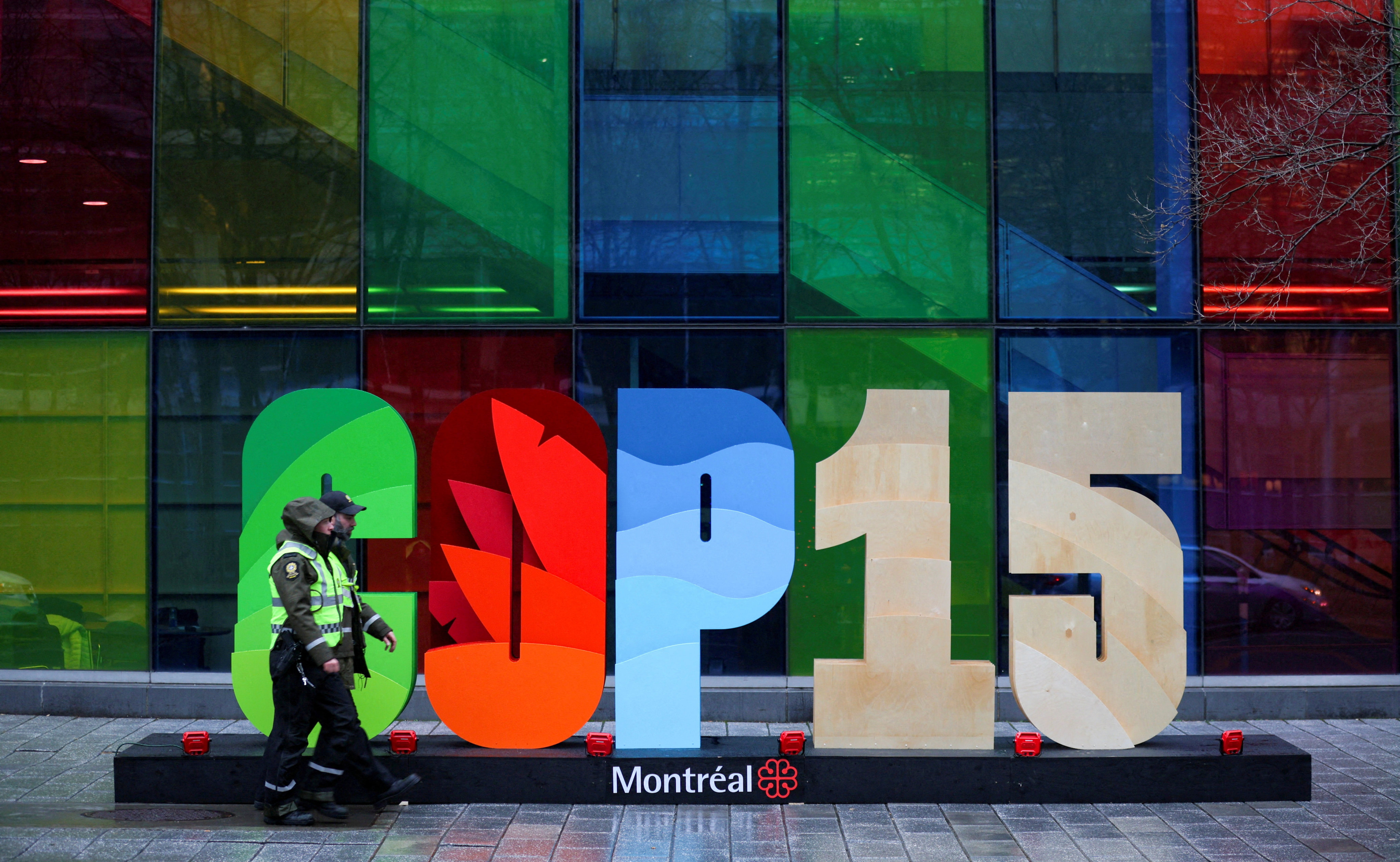 Police officers walk past a sign outside the Palais de Congres, during the COP15 UN biodiversity summit in Montreal, Quebec, Canada. Reuters