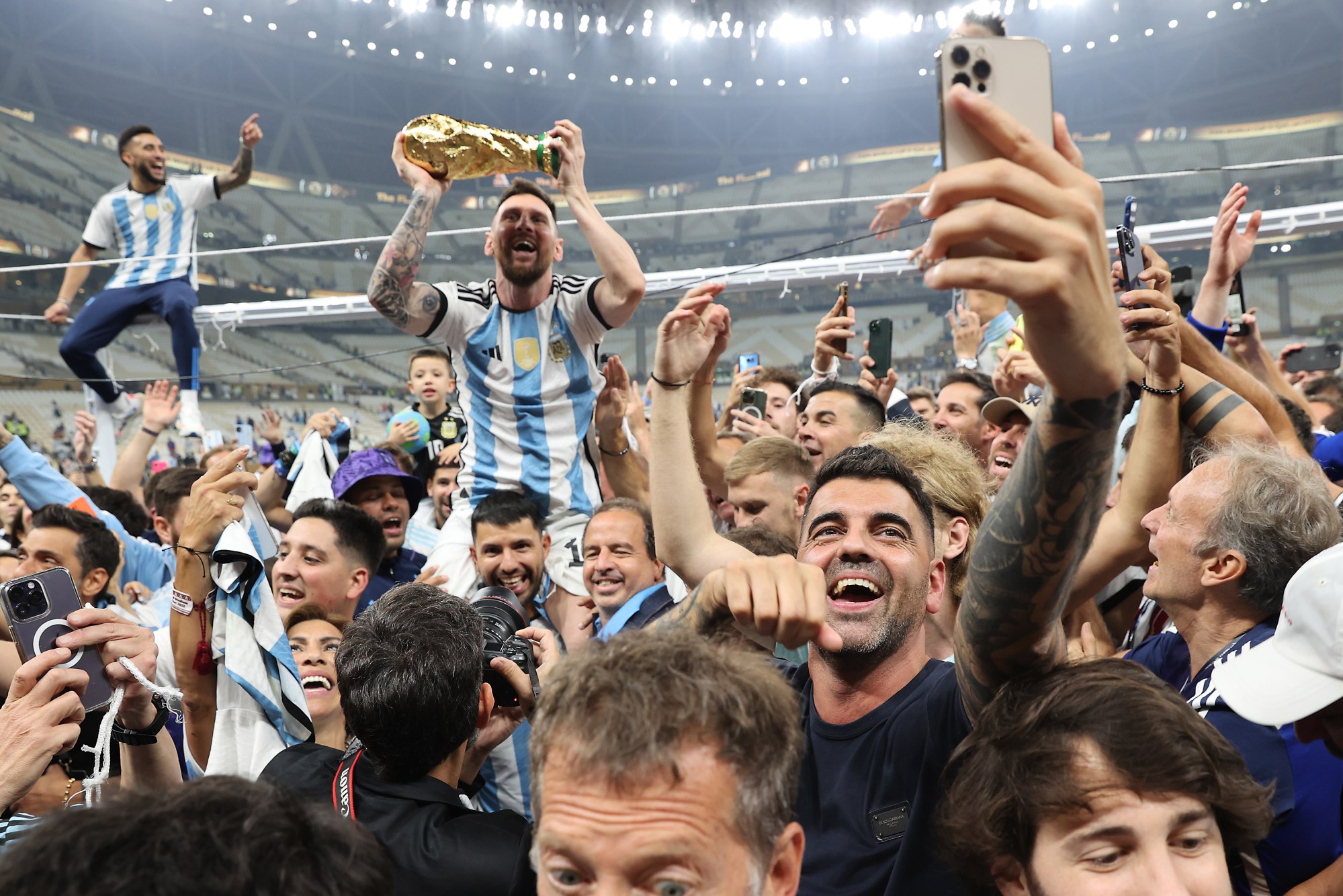 Messi lifts the trophy as he celebrates with teammates and fans after winning the World Cup final against France on Sunday. Photo: EPA-EFE