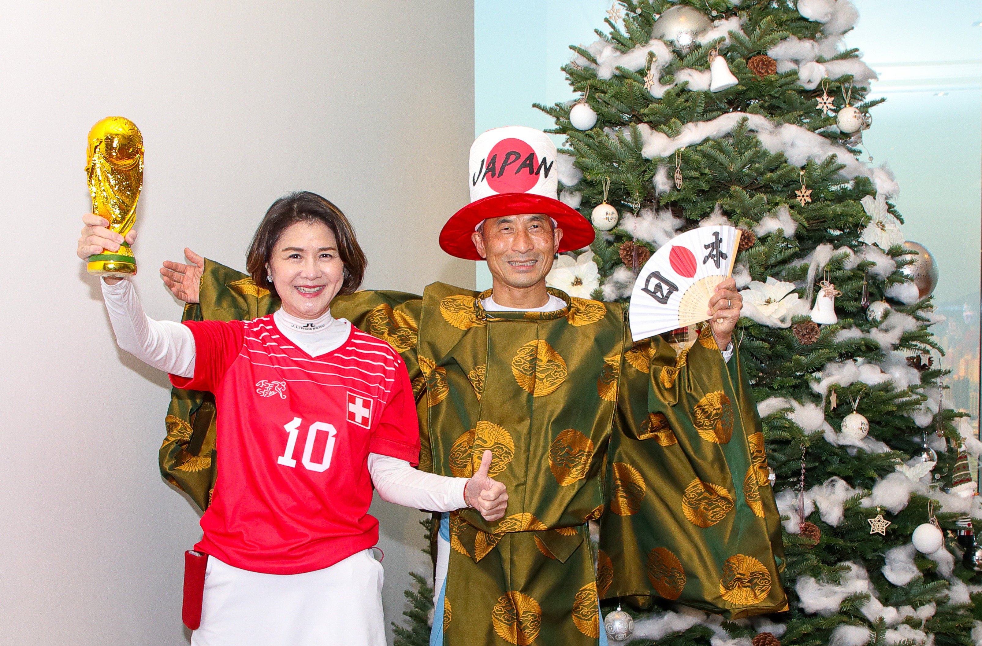Amy Lo, chief executive of UBS Hong Kong, and Taichi Takahashi, head of investment bank for Asia Pacific, dress in their World Cup best during a fundraising event in support of Operation Santa Claus. Photo: Bharat Khemlani