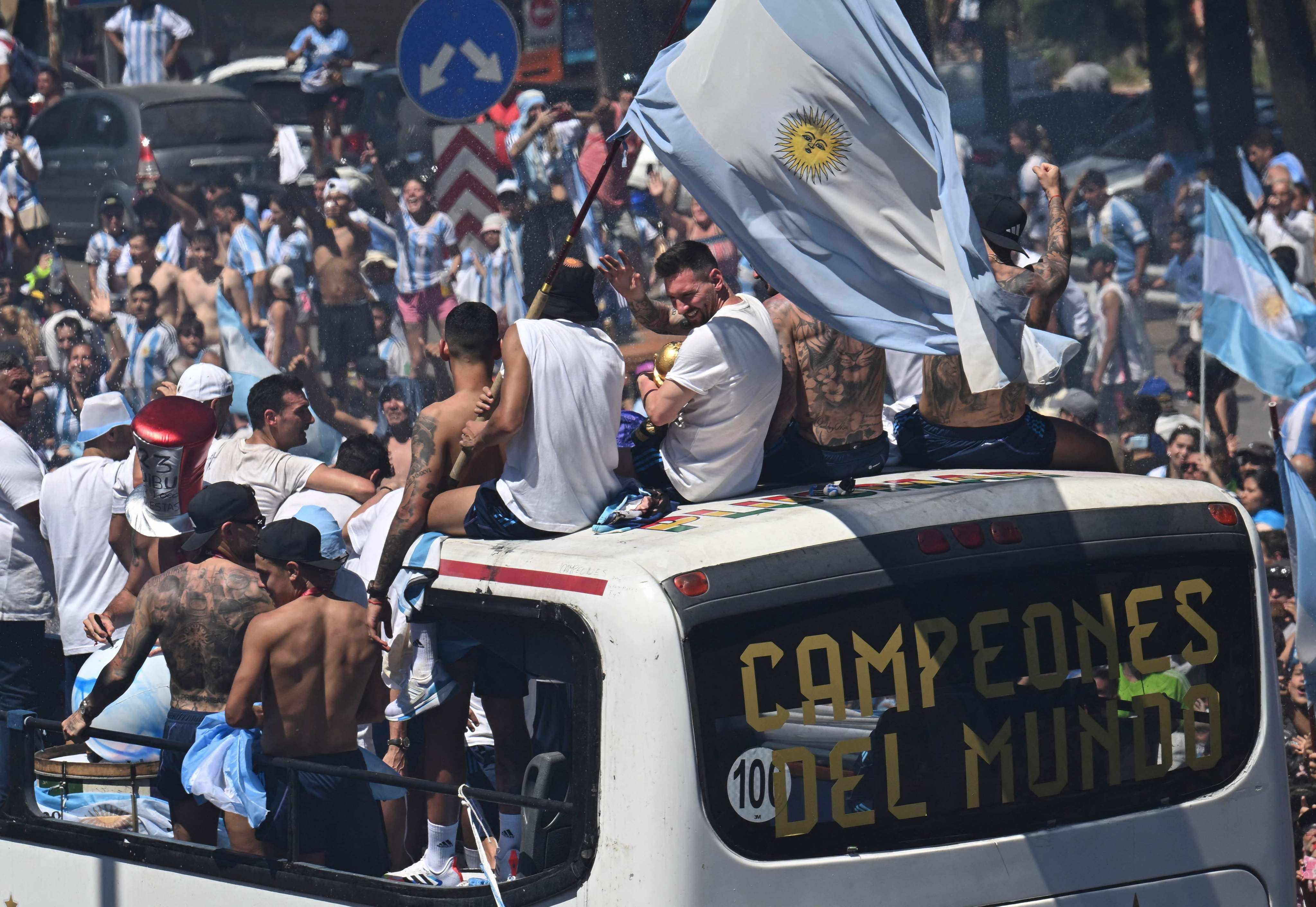 Argentina’s players celebrated with their 2022 World Cup trophy on board a bus as they began their open-top bus parade tour through Buenos Aires on December 20, 2022. Photo: AFP