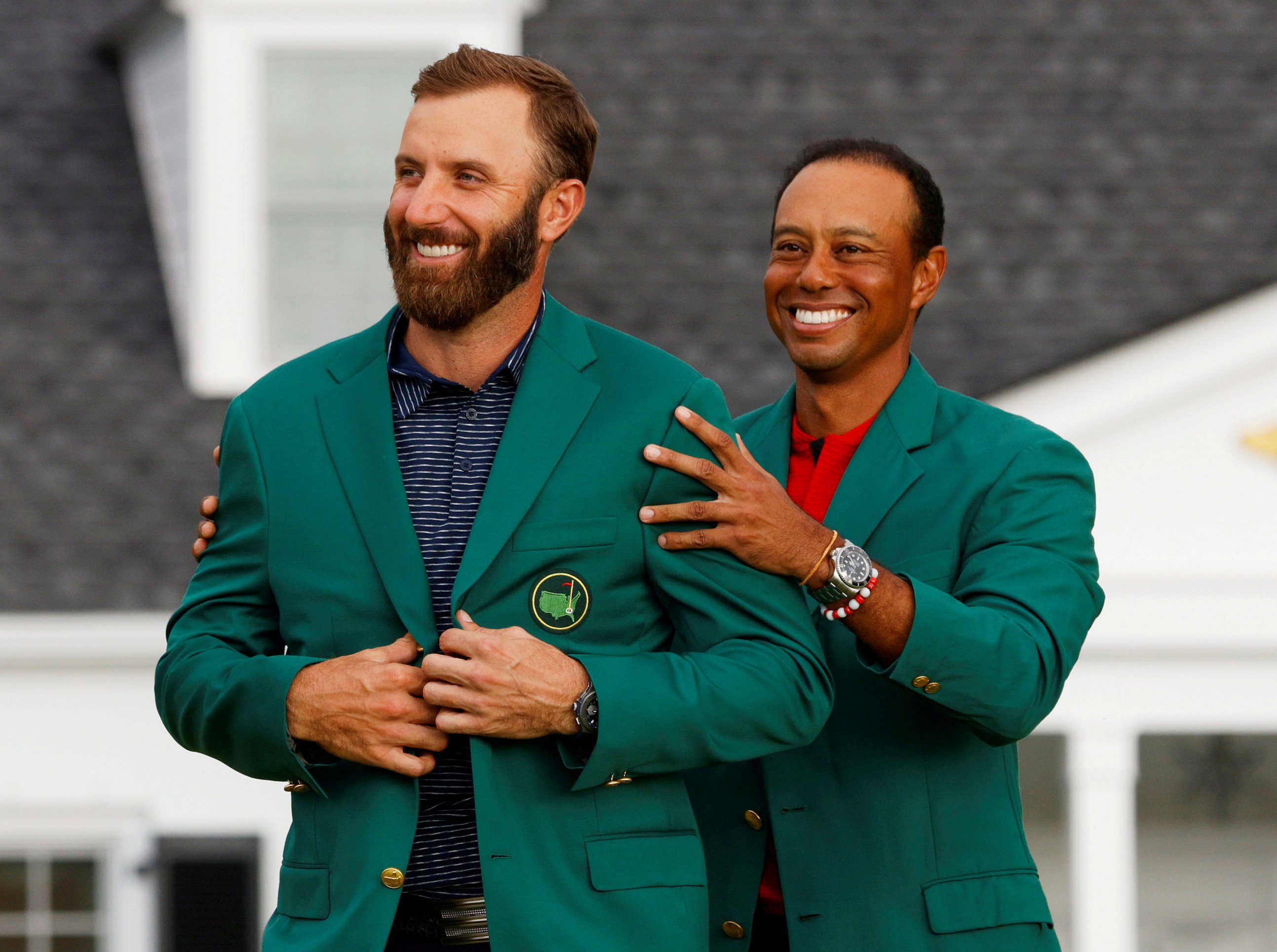 Dustin Johnson is presented with the green jacket by Tiger Woods after winning The 202 Masters. Photo: Reuters