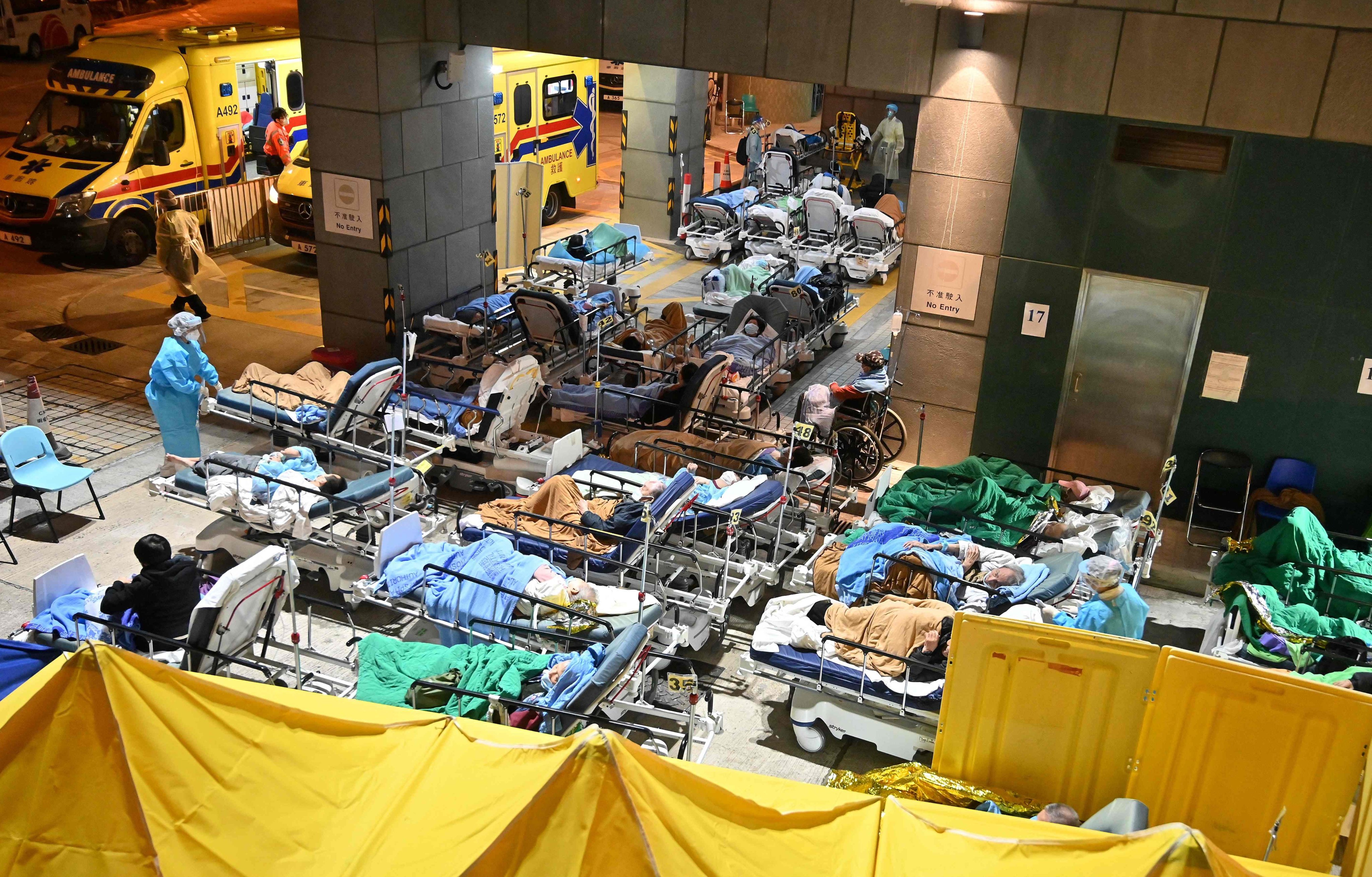 Patients lie in hospital beds as temperatures fall at nighttime outside the Caritas Medical Centre in Sham Shui Po on February 16. The fifth wave that started the year marked one of the lowest points of the pandemic for Hong Kong. Photo: AFP